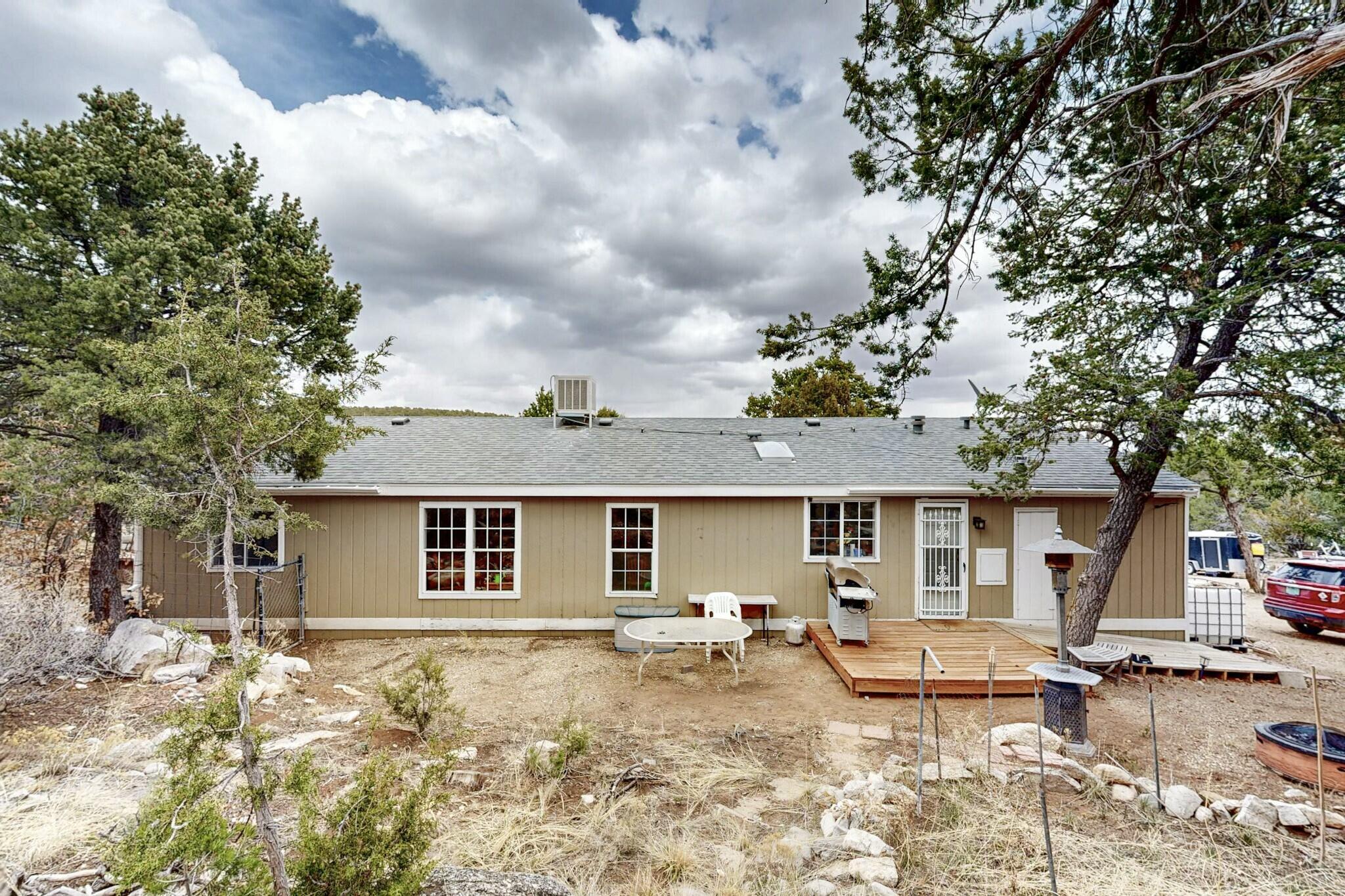 Escape to peaceful country living at 15 William Bonney Rd in Edgewood, NM. This charming 3-bed, 2-bath updated manufactured home is nestled on 2 private acres surrounded by mature pinon trees and breathtaking views. Inside, you'll find an open floor plan, modern finishes, and a granite kitchen perfect for cooking and entertaining.The property is located in a quiet, remote setting--ideal for those seeking space, nature, and a slower pace of life. Plenty of room to garden, expand, or simply unwind.The home uses a 1,000-gallon cistern system for water. Water is hauled in and can be delivered by East Mountain Water Hauling for around $100 per 1,000 gallons. To make things even easier, the seller is including a 275-gallon portable water tank and a 2'' transfer hose.