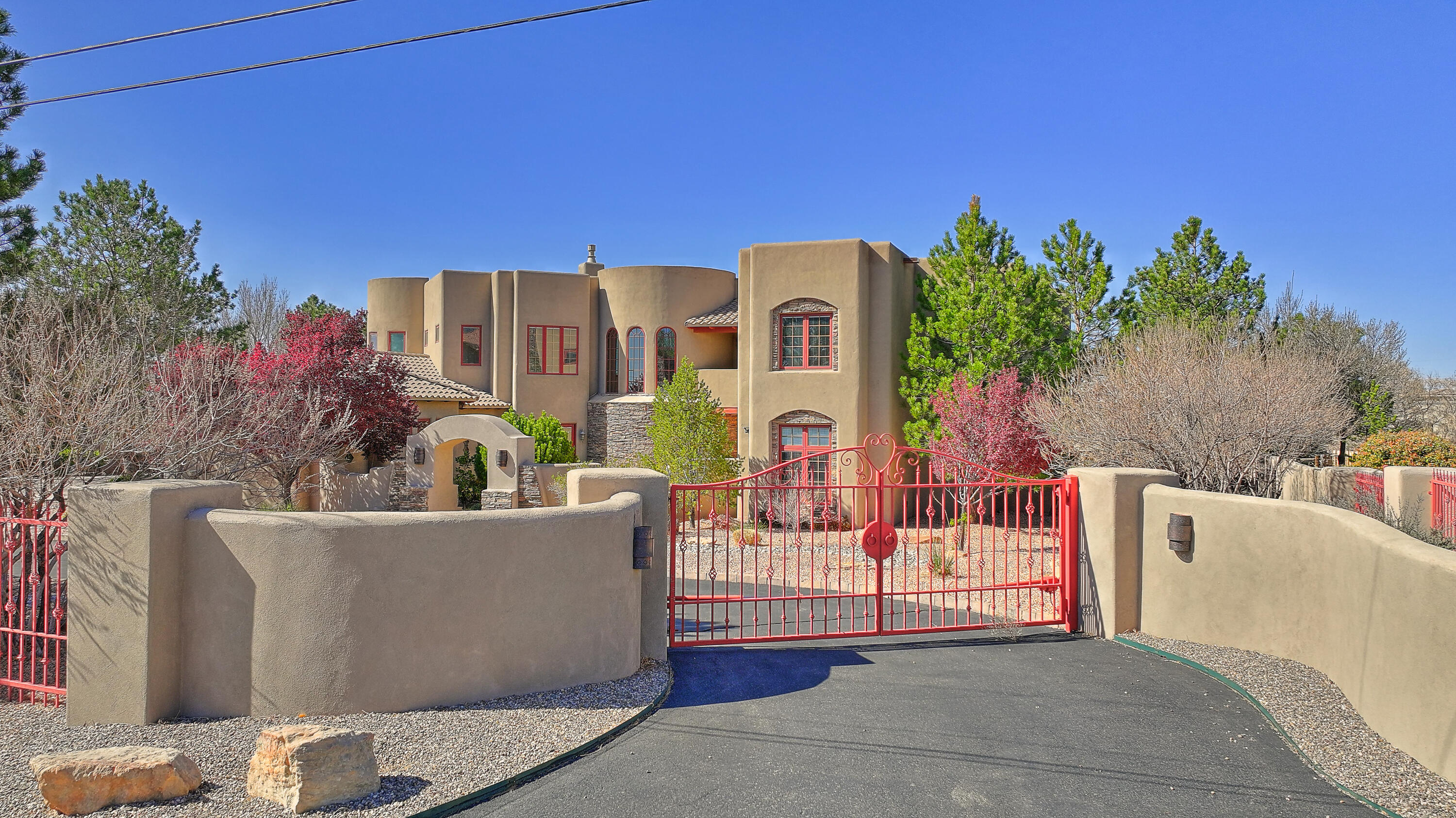 Meticulously maintained, exquisite, one-of-a-kind estate in North Albuquerque Acres features VIEWS, Quality, and a rare opportunity! The grand courtyard and entrance welcome you. Enjoy the spacious living space, spectacular gourmet kitchen, and large formal dining room with courtyard access. The flowing floor plan displays luxury details and quality in every room. Each bedroom is unique and beautifully designed, featuring an ensuite and views. The owner's retreat boasts a private sitting area, fireplace, balcony, coffee bar, and spacious bath, providing a private escape at the end of the day. Spectacular landscaping, a custom pool, a hot tub, a putting green, and a built-in trampoline framed in mountain VIEWS for optimal lifestyle! Tesla charger, four car garage, storage, SOLAR power!