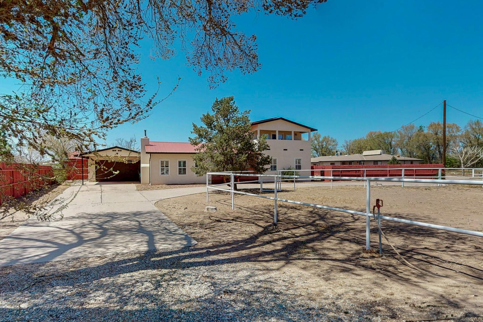 Open House Sat &  Sun! This beautifully updated home on 0.78 acres is a dream for horse lovers, outdoor enthusiasts, and anyone seeking space, comfort, and incredible views. The property includes a horse ring, covered hay storage, backyard access for RVs and trucks, and a heated & air-conditioned tack room that doubles perfectly as a private office.Step inside to enjoy a fully renovated kitchen with stainless steel appliances, newly updated bathrooms, brand-new carpet in the bedrooms, and a HUGE primary suite with stunning Sandia Mountain views.Just 2 minutes from Balloon Fiesta Park, you'll have a front-row seat to watch hundreds of hot air balloons rise into the sky each fall during the world-famous Albuquerque International Balloon Fiesta!Solar Panels help reduce elec bill!
