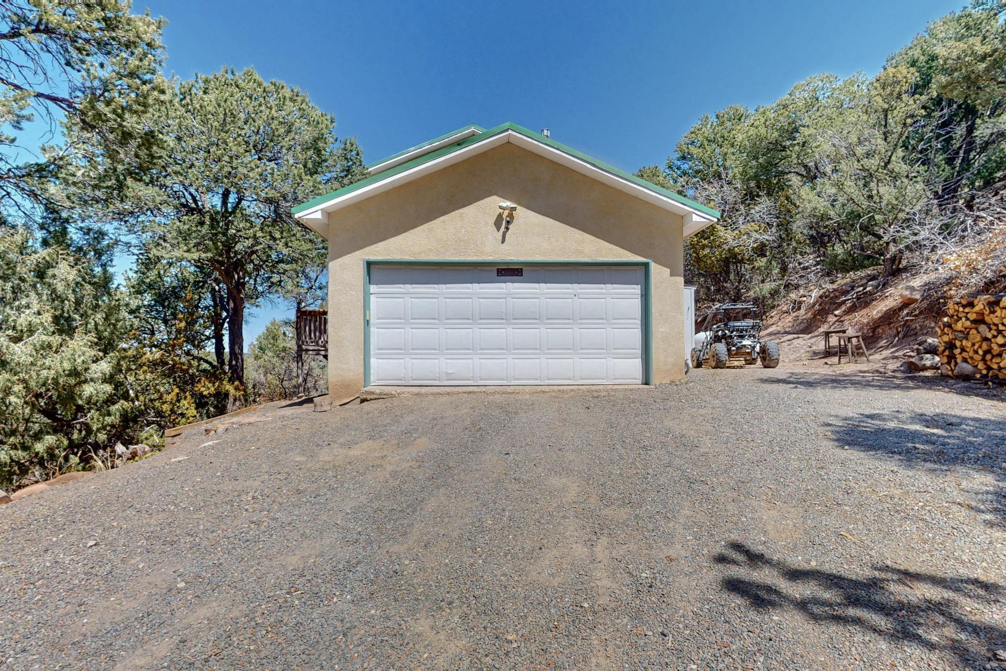 Stunning Woodland Home with Views!Escape the bustle of the city and embrace the tranquility of this beautiful 3 Bedroom 2 Bath Home. Nestled among the trees with an enchanting walking path panoramic views, all just 15 minutes from Albuquerque!  Recent updates for modern comfort: Freshly remodeled kitchen and bathrooms, blending stylish finishes with functionality; Pellet stove, water heater, and boiler system--all newly installed within the last two years! Cozy up on winter nights in front of the  fireplace as this home comes with nearly a cord of firewood. Soak in the beauty of nature from your expansive wrap-around deck, the perfect setting for private or social gatherings. Don't miss the chance to make it your own, contact your realtor today!