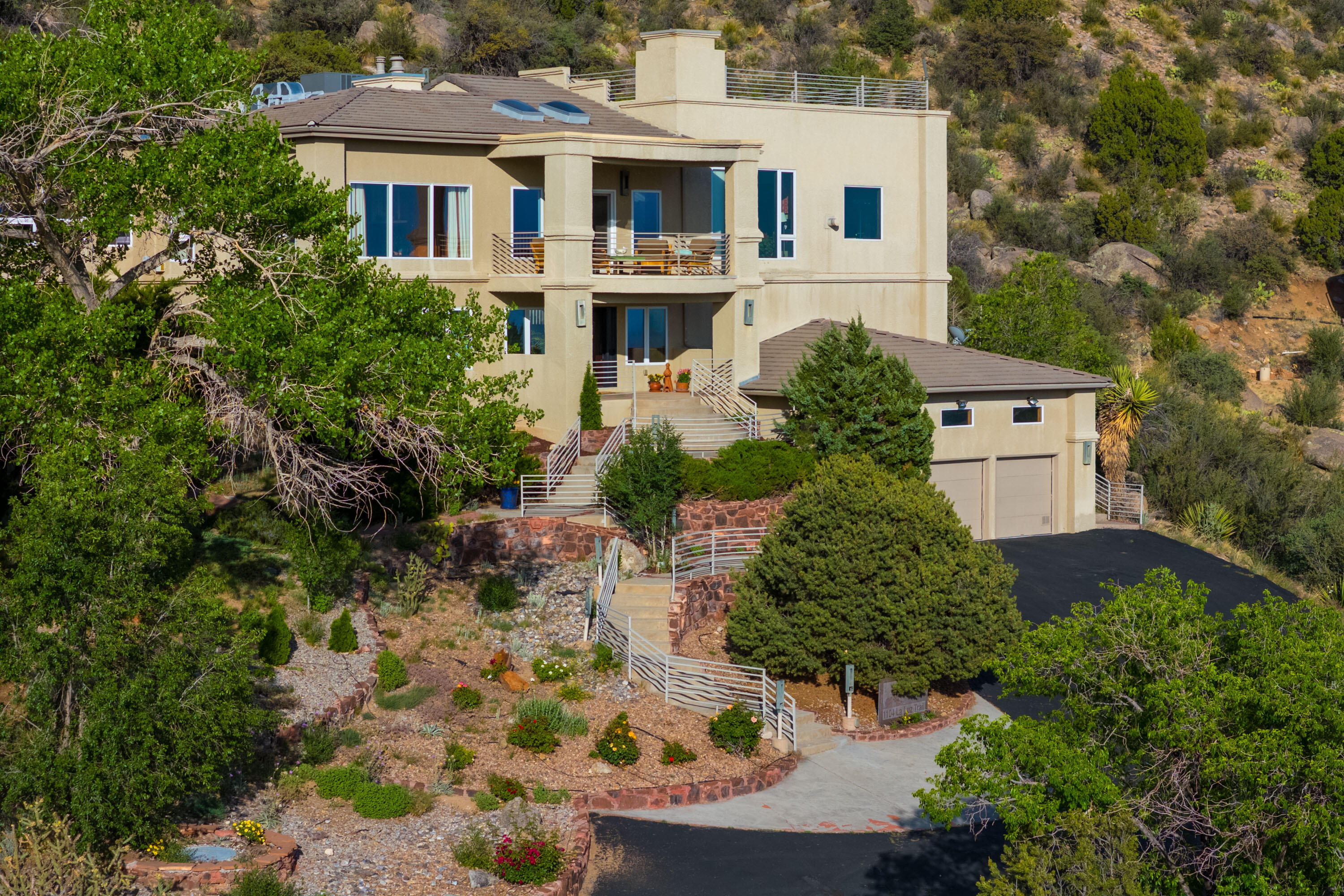 Sitting Tall among the Sandia Mountains you will enjoy spectacular views & Privacy from this uniquely styled home. Stunning, Spacious & Soaring ceilings with light filled rooms & walls of windows. With over 6200sq ft of living space, the home includes a great room w/ bar and a Wine room(temperature controlled) that stores 1600 bottles. Designed for entertaining. Among the 4 bedrooms & 5 bathrooms, one on the ground floor accommodates multigenerational living. The culinary kitchen offers solid wood custom cabinets, high end appliances, breakfast nook or dine al fresco on one of the outdoor patios. Formal dining area features large floor-to-ceiling windows that offer enchanting views. The outdoor living spaces include a heated pool, cabana, several terraces & hot tub. Travel up the stairs