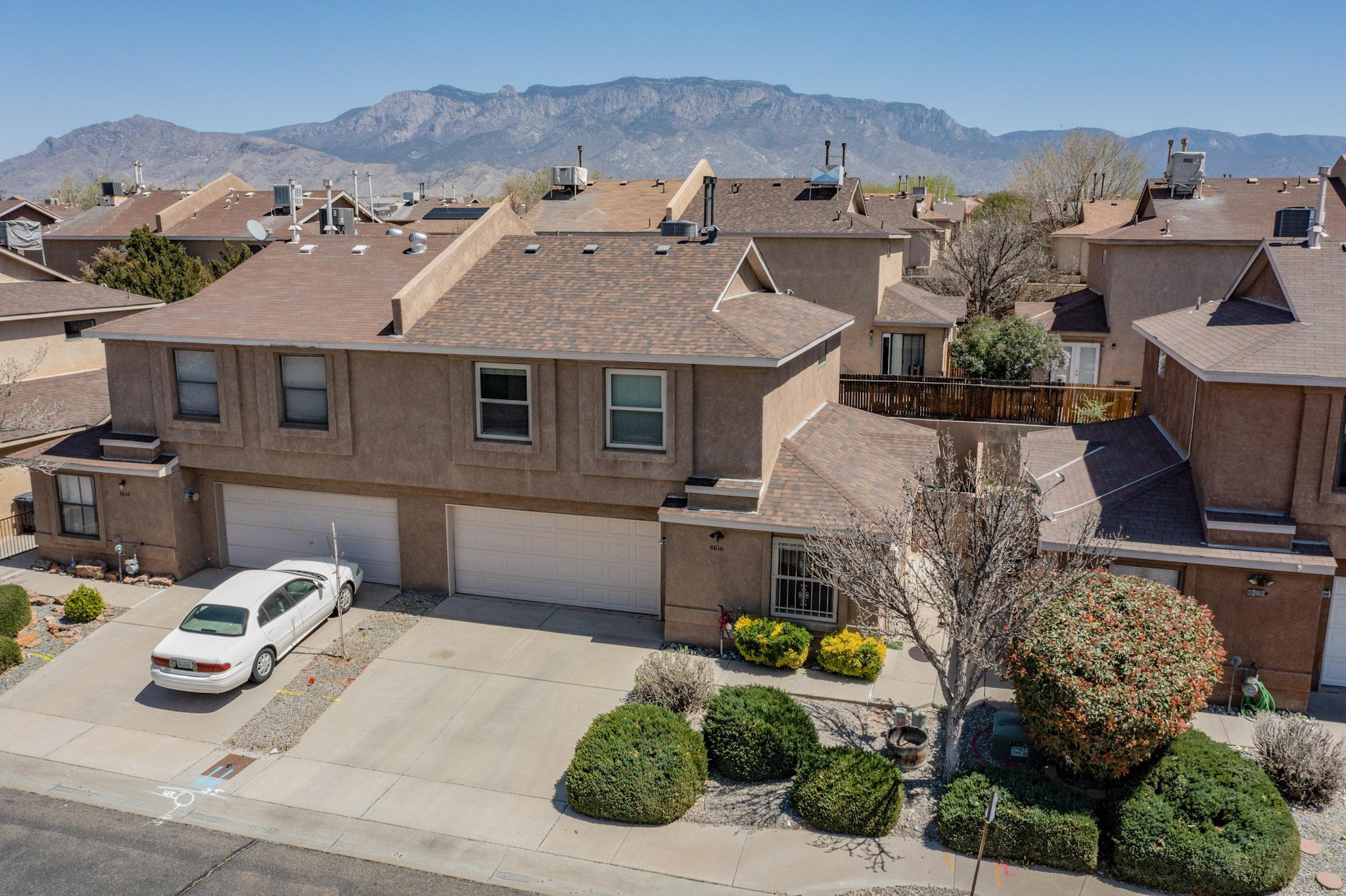 This move-in-ready townhouse offers the perfect blend of location, convenience, and low-maintenance living. NEW ROOF  (2022) and NEW REFRIGERATED AIR (2023), an attached two-car garage, and HOA-covered front yard and common area maintenance giving you more time to enjoy your home and neighborhood. Inside, you'll find a bright, open floor plan featuring durable tile and laminate flooring throughout (no carpet), combining style with easy upkeep. The spacious living area welcomes you with a cozy gas fireplace, perfect for relaxing evenings at home. The  kitchen is a standout, equipped with stainless steel appliances, granite countertops, ample counter space, and a generous walk-in pantry tucked under the stairs. Enjoy being just minutes from North Domingo Baca Community Center & a Park..