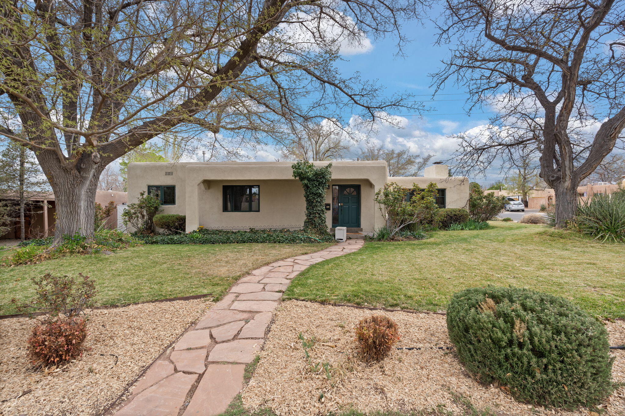 Step into timeless charm & character on this beautifully landscaped corner lot, where original oak hardwoods & coved ceilings set a warm, elegant tone. Updated kitchen shines w/ granite counters, recessed lighting, & mini butler's pantry. Kitchen is open to great room w/ new carpet, fireplace, & french doors to pool deck - perfect for entertaining! The primary suite has private access to hot tub and pool.  Quiet study with built in shelving for your home office. 1/2 bath off patio is convenient for pool guests. Secure, covered, off-street parking & gardener's paradise w/ lush lawn & blooming flowerbeds in the front & flower boxes around the sparkling pool / hot tub out back. Fresh paint throughout! Flexible layout offers 2 or 3 bedrooms and 2 living rooms. Near UNM & Nob Hill