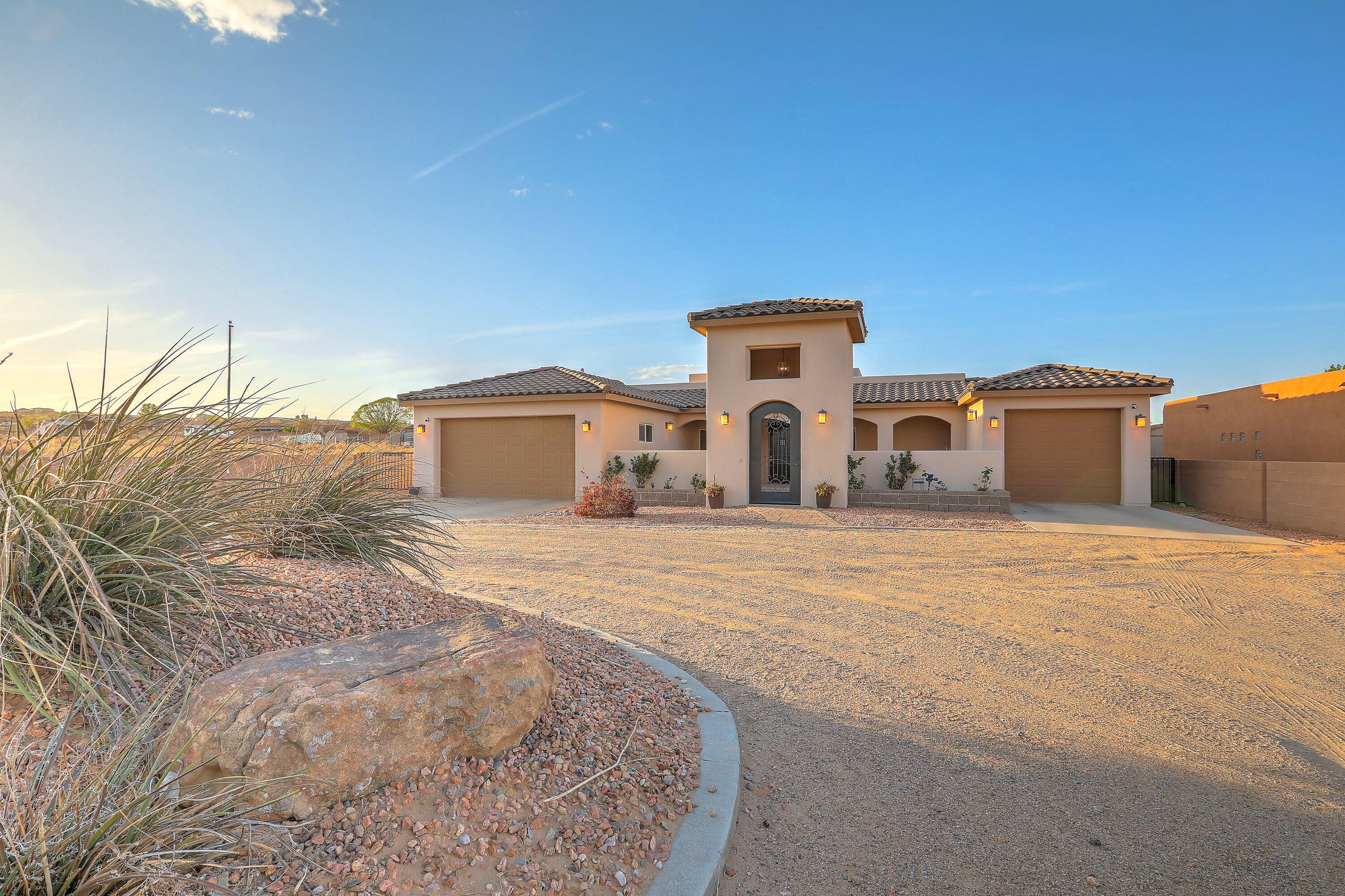Discover refined living in Rio Rancho. This stunning home features 12 foot cielings in the main living area.  Chef's will delight in the  kitchen with gas range cooktop, stainless steel appliances, and tons of cabinet space. The primary suite is grand with high ceilings, en-suite bathroom with dbl vanities, spacious shower, tub, and beautiful closet. Offering five spacious bedrooms, along with an office and den, perfect for work or leisure. Enjoy your private outdoor living space, complete with a fully equipped outdoor kitchen, perfect for hosting gatherings or enjoying tranquil evenings. The covered porch provides the ideal spot to unwind while appreciating the stunning sunsets. With two-car garage and an additional third bay, this property harmonizes luxury and practicality.