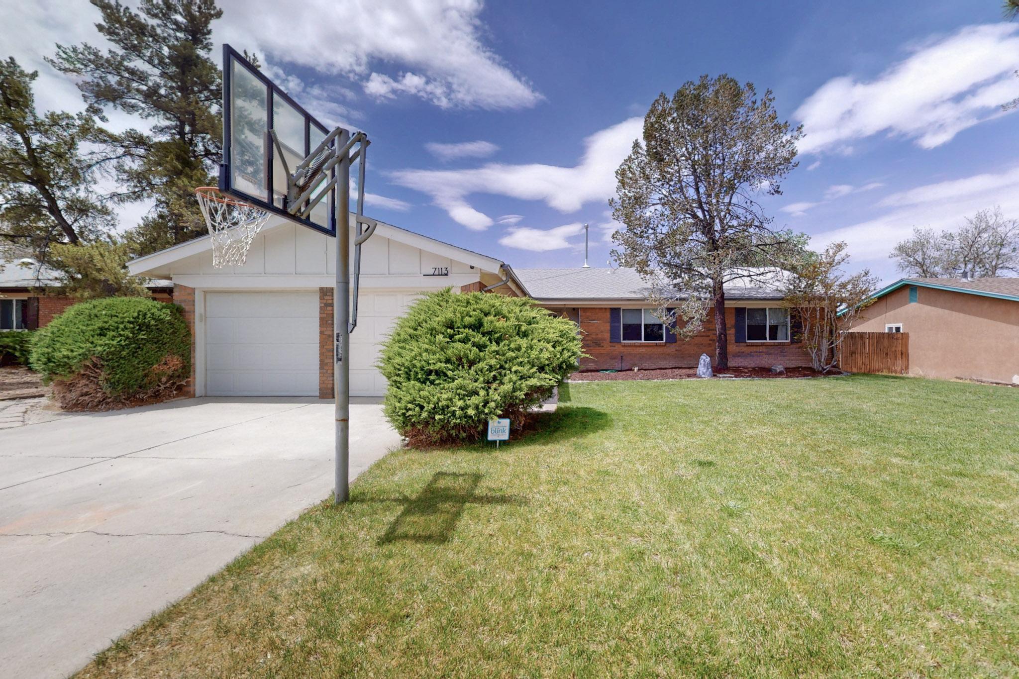 Immaculate 3 bed, 2 bath home in a beautiful NE Heights neighborhood, plumb full of amenities and updates. From the lush front lawn with mature trees, the brick veneer stretching around the house, and solar panels, step inside to this warm and inviting home. The kitchen with stainless appliances and granite countertops flows into the dining and living room which features vaulted ceilings, exposed wood beams, cozy brick wood-burning fireplace (with wood mantle!) and is bursting with light from the large picture windows overlooking the backyard. The extra-large primary bedroom has space for a private sitting area and has its own 3/4 bathroom and towel warmer. Don't miss the sunken den/office/flex space, oversized garage with workshop/storage space, covered backyard patio, and so much more!
