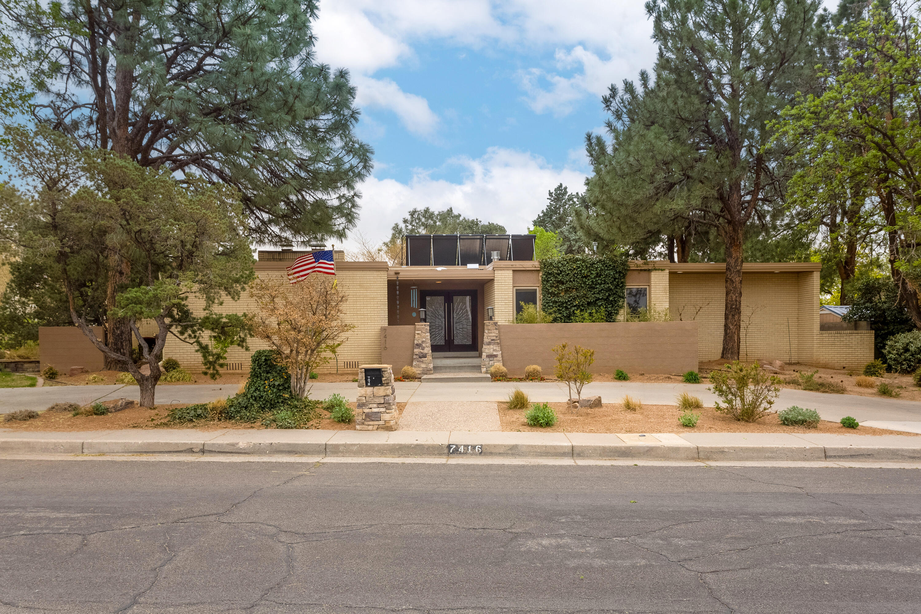 The magnificent front door draws you into a bright spacious foyer and invites you into the large living room with a view of the indoor pool.  The bedroom wing features an impressive primary bedroom with fireplace, and en suite with stand-alone tub, oversize shower and custom cabinets accented with granite and stone. The remainder of the wing has two bedrooms separated by a jack-and-jill bath. The open kitchen has upgraded appliances including a 42'' Sub-Zero refrigerator, dual Fisher-Paykel dish drawers, and a dual-fuel range. Custom cabinets have special features such as pullouts, lazy-susans, and an appliance lift. Updated Pella windows add to the efficiency. Surrounding the home is a professionally designed and fully irrigated landscape that was featured in the 2024 Garden tour.