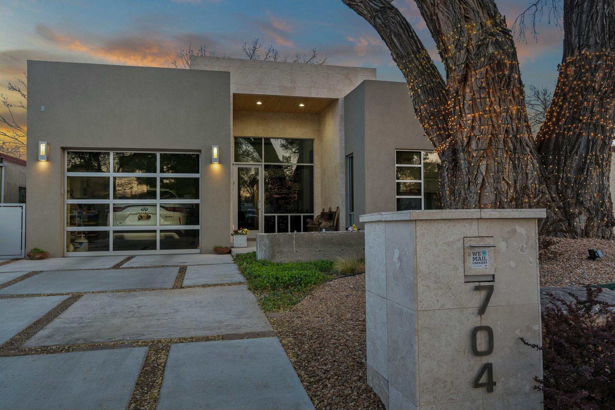 Under the changing foliage of an aged-cottonwood sits this spectacular contemporary single-level across from  Albuquerque Country Club. Enter the high-ceilinged gallery entry to a highly-flexible floorplan that accommodates many different lifestyles. Light flows into a bedroom/office from a large window that truly forms a picture of views of the area foliage. The living area features built-in bookcases and a glass-enclosed gas fireplace. Read, play or workout in the flex-space that could be a fourth bedroom.The kitchen was recently updated with marble counters and ceramic subway tile. A second bedroom with wood flooring has a bathroom adjacent. The primary bedroom features wood floors and  picture window. Enjoy the low-maintenance backyard that combines xeriscaping and beautiful gardens.