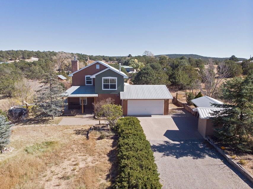 How about this mountain retreat on just over an acre of land, conveniently located within minutes to Albuquerque, this is your new home! Withtons of natural lighting, this home is what you have been waiting for. The back covered porch area is great for bird watching and having a BBQ.  Updated tile flooring, wood beams and a pellet stove in the living room, stainless steel appliances and pine cabinetry in the kitchen.  The owner's suite features views of the Sandia mountains to the East, with a walk-in shower, granite countertops, and double sinks! The two guest bedrooms share a full bathroom, also with two sinks. Nice little out buildings, plenty of trees, this house is ready to go.  Don't forget the chicken coop ready to be re-chickened!!