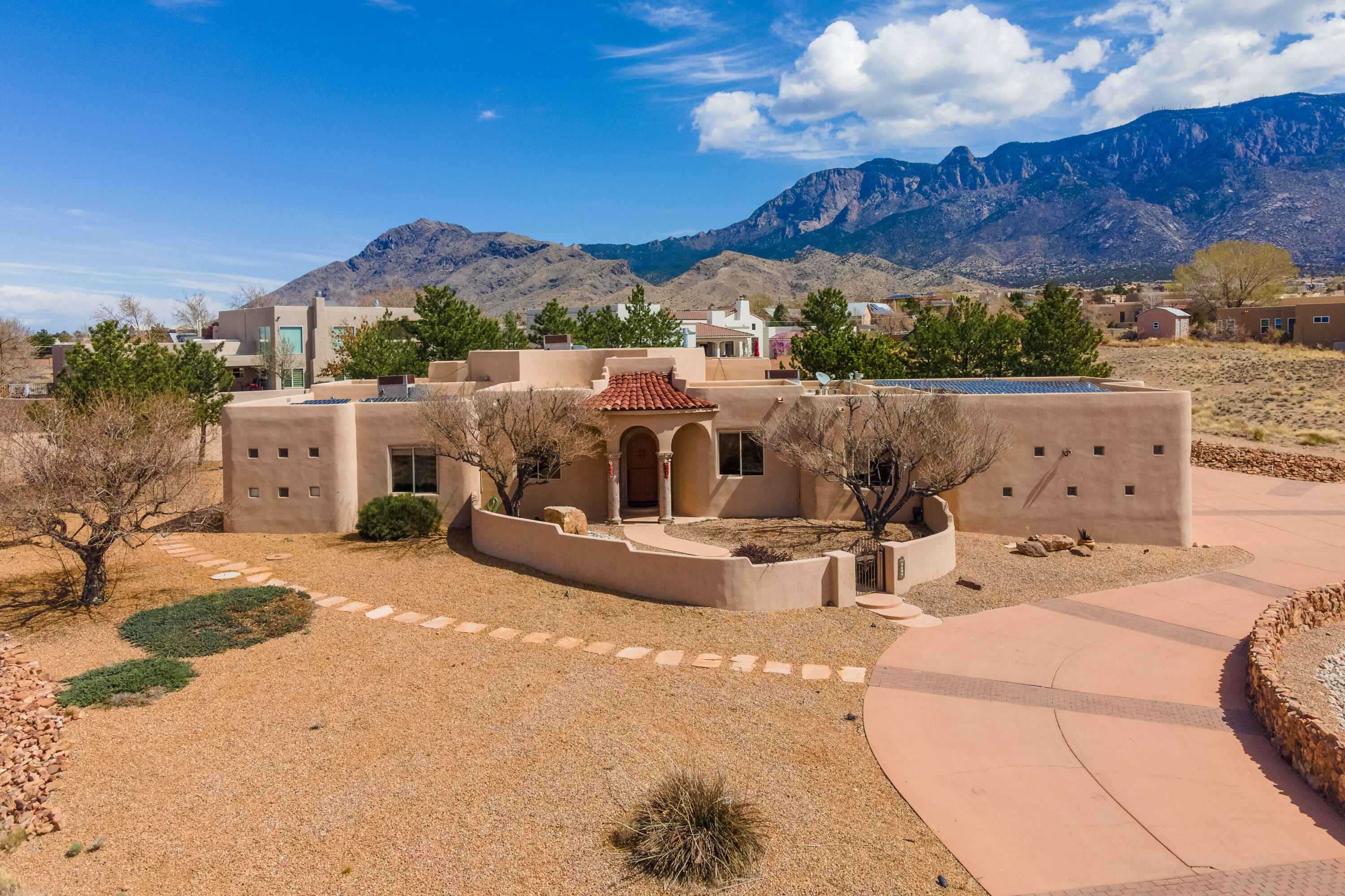 Absolutely stunning custom Tuscan home with over 3000 sf, 4 bedrooms, and 2.5 baths, boasting gorgeous mountain views on an .89-acre lot.  Enjoy magnificent views of the Sandia Mtns  from many rooms in the house and from the private backyard.  This meticulously designed home which includes hand carved Cantera stone columns, refrigerated air conditioning, and radiant heat for ultimate comfort. The gourmet kitchen is equipped with Jenn-Air appliances and custom cabinetry, perfect for the most discerning chef in the family. The expansive primary suite offers luxury and comfort with a spa like bathroom and large walk-in closet.  The professionally landscaped front and back yards add to the allure of this property. Bonus Solar is owned 9.6kw peak output.  Huge 3 car Garage with RV Door