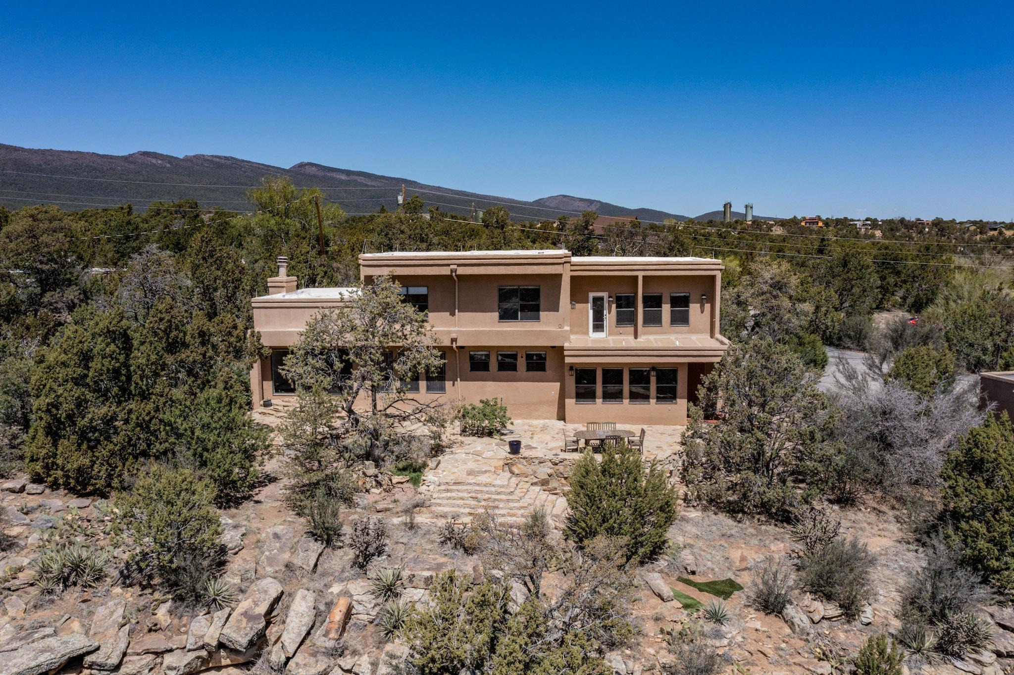 Breathtaking views from this custom home perched high above the valley floor. This exceptional custom home offers sweeping views of the Sandia and Manzano Mountains and a lifestyle immersed in natural beauty. Set on nearly 2.9 acres. This two-story, 3 bedroom, 3 bath residence features indoor-outdoor living, perfectly suited for the high desert.The stone patio is crafted from rocks harvested right from the property's cliff. Offering a dramatic overlook hundreds of feet above the valley. Massive boulders serve as peaceful perches to watch hawks and ravens glide the thermals while a tranquil water feature regularly draws in hummingbirds beneath the shade of the pinon trees.A truly rare feature, the property includes a 14' x 14' private observatory with a fully functional hemispherical