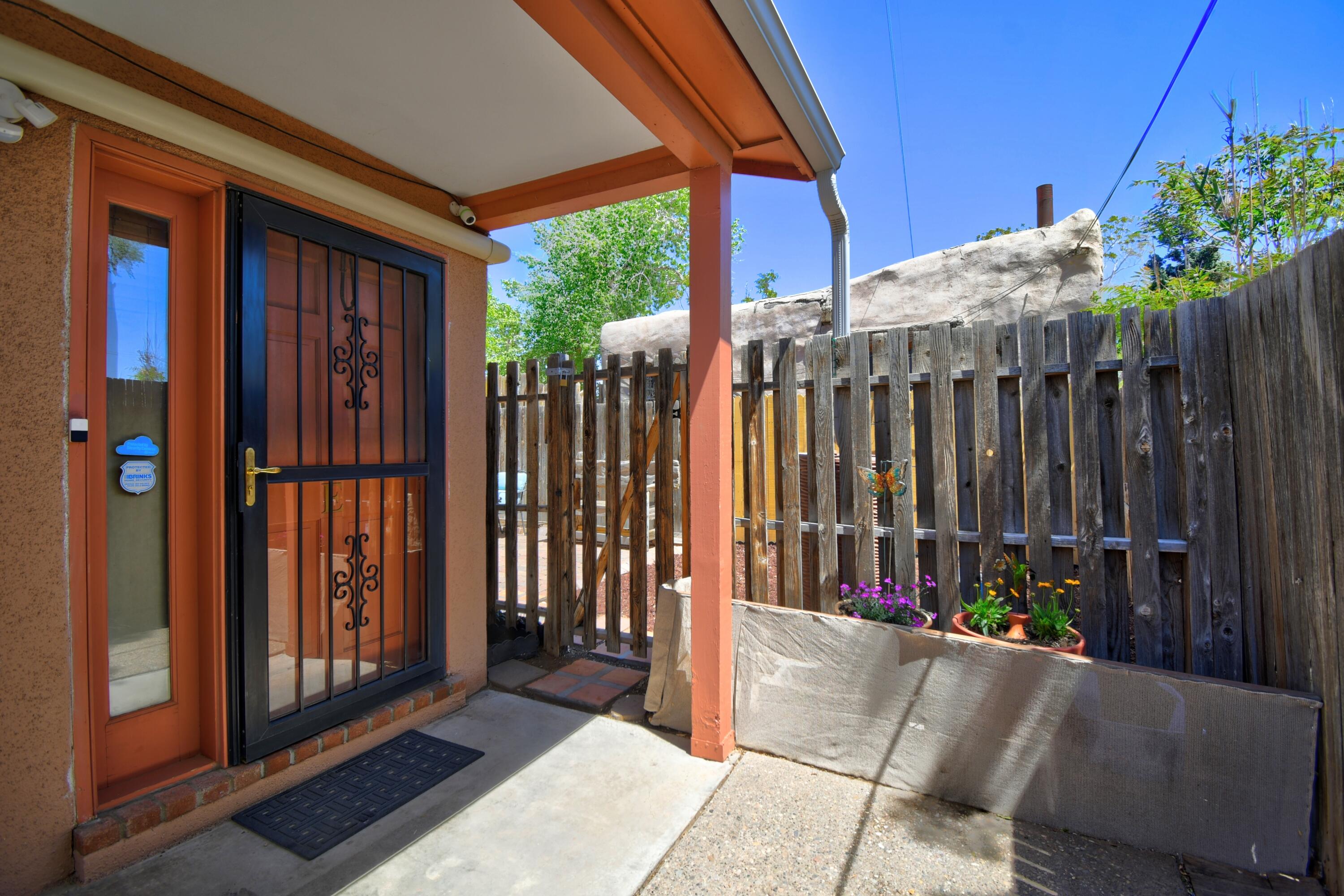 Come and be charmed! This stylish home is close to Old Town, museums, galleries, parks, restaurants, etc. The private end unit has two wonderful balconies with sunset and mountain views. The warmth of brick floors, exposed adobe walls, and a kiva fireplace are the essence of New Mexico. The living room opens to a lovely outdoor space. There is a double carport with a storage unit. Master bath has a shower and a separate tub.  The upstairs flooring is rustic wide plank wood.  This is the total package.  Come and enjoy!!!