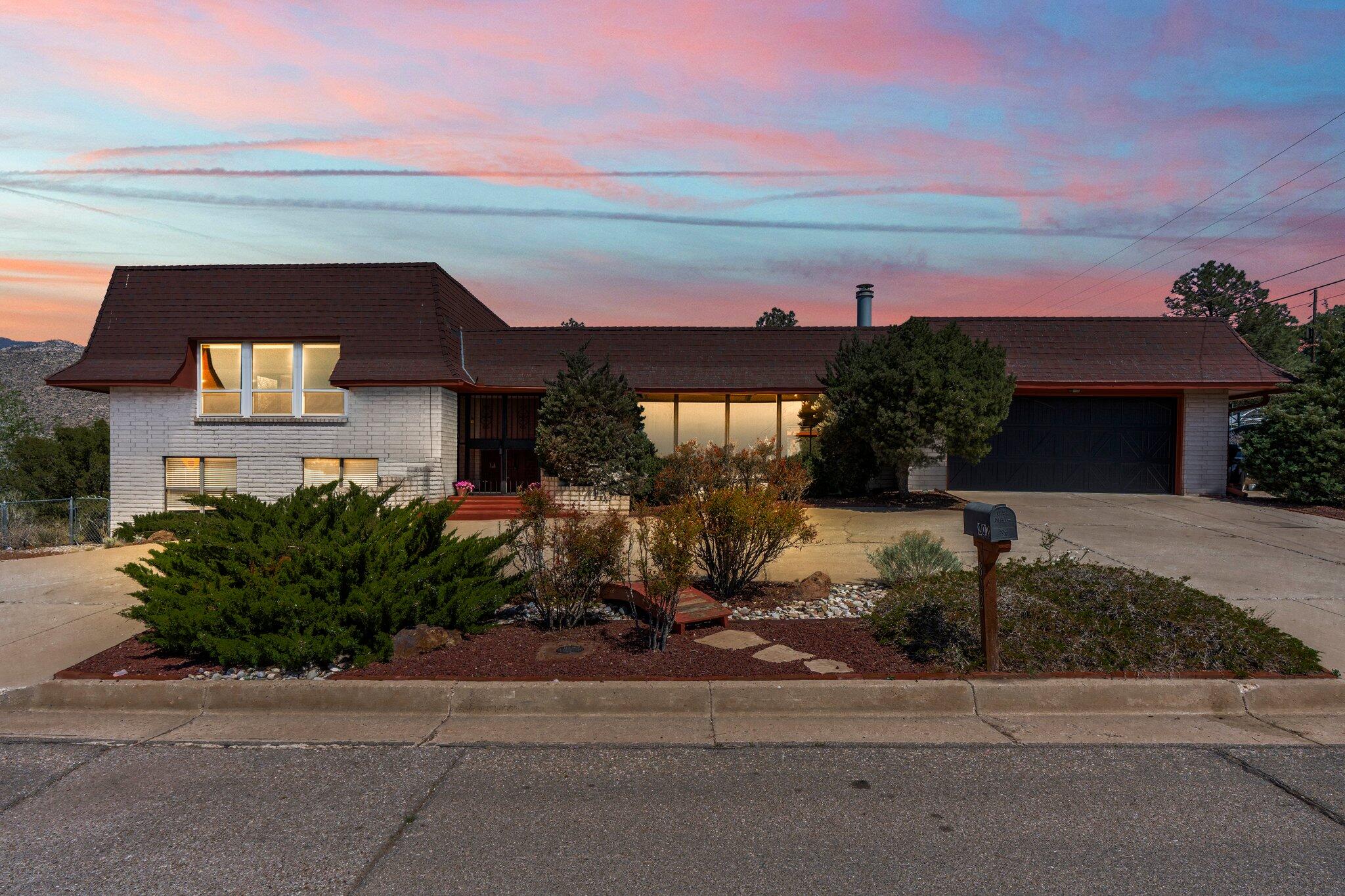 PRICE IMPROVEMENT!! MOTIVATED SELLER!! Welcome to this beautiful 4-bed, 3-bath, 2,880 sq ft split-level home in Four Hills! Views of the city & mountains. Bright double-door entry with skylight leads to two living areas, one with a stone fireplace and wet bar. Kitchen features a custom Sub-Zero fridge and double oven. Grand upper-level primary suite with private balcony, mountain views, jacuzzi tub, and walk-in closet. 3 bedrooms on lower level one. Recent updates include luxury vinyl floors (2023), interior paint (3/2025), and new garage door and motor (5/2025). Deck, circular driveway, spacious 2-car garage, RV pad and solar panels (loan assumption required). Don't miss this amazing opportunity!