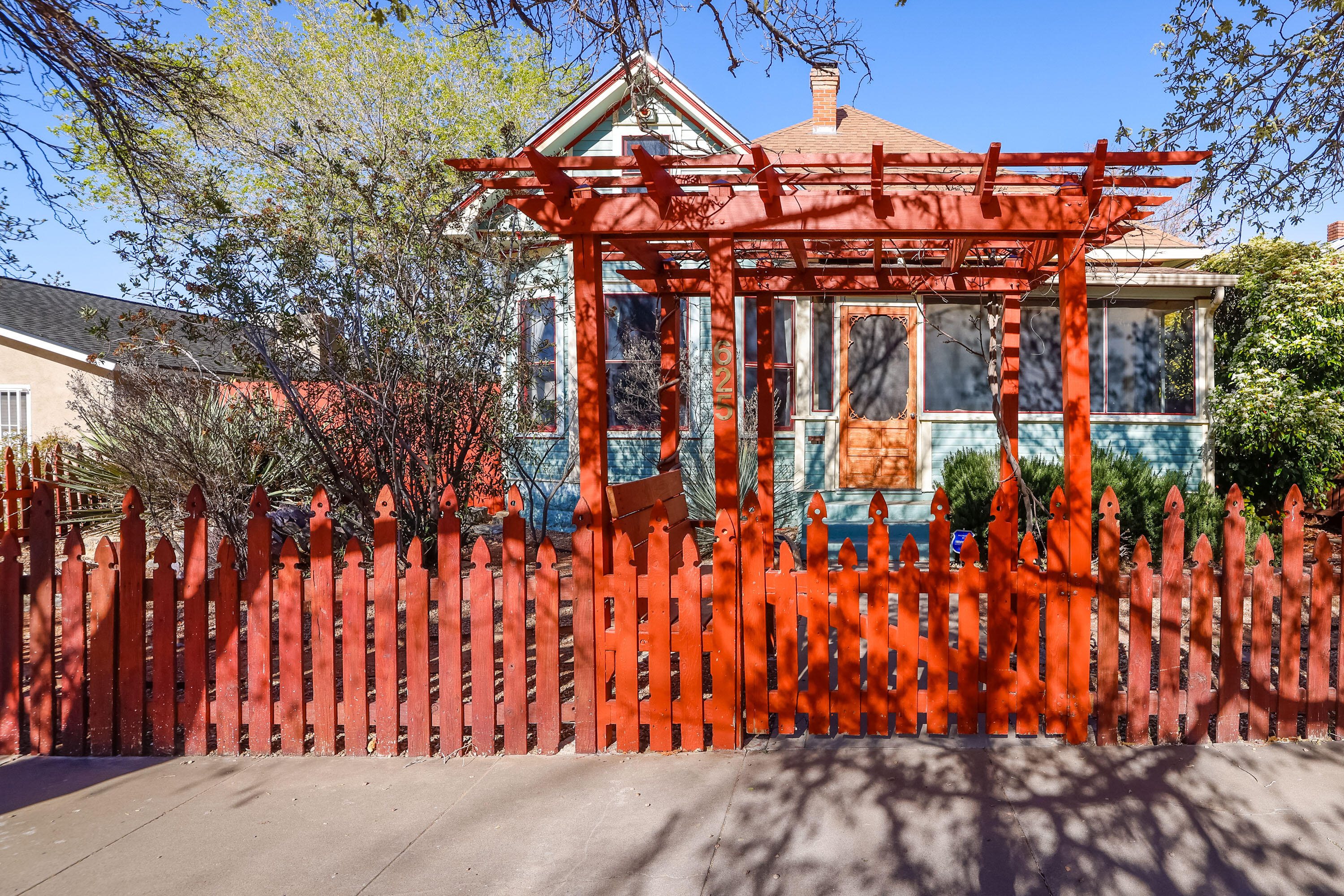 1907 Queen Anne Bungalow.  Enter the relaxing screened porch into beautiful Living Room.  Formal Dining Room and Large Modern eat-in Kitchen.  3 Bedrooms and 1 3/4 Bath.  Master Suite has sitting room/office and large bathroom.  Laundry room has storage as well as a partially basement.  Covered 2 car parking with automatic door off the alley.  Original wood floors and wood work throughout.  Refrigerated air, fully fenced yard.  Listed on the State of NM registry of Historic Places.