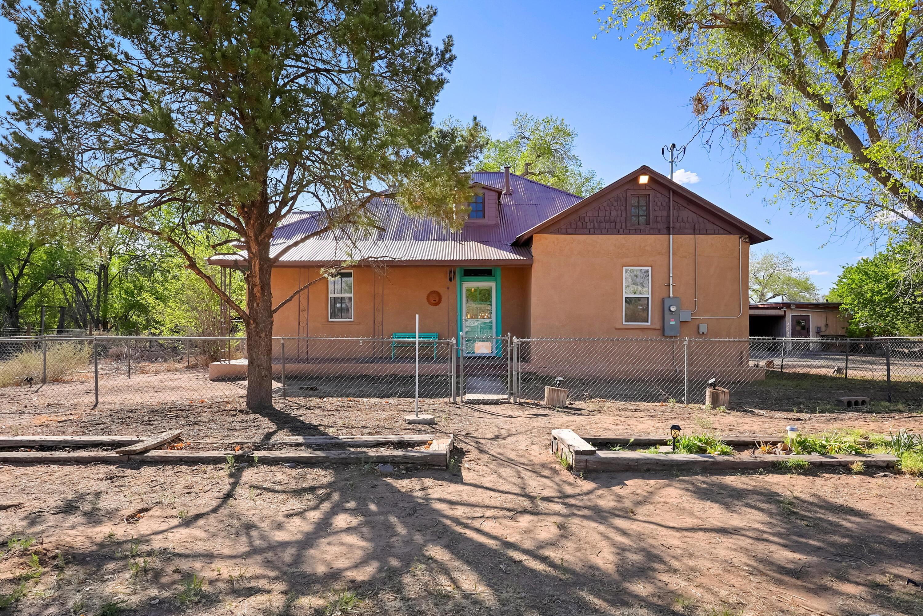Out Where the Sidewalk Ends - On the Northern edge of Albuquerque's North Valley, and Nestled on a Spacious 1.5-Acre Corner Lot, this Charming Vintage Northern New Mexico style Adobe Home Captures Stunning Sandia Mountain Views and holds Endless Potential. With it's Rare Blend of Rustic Charm and Natural Beauty, a Detached 2 Car Garage, Detached Workshop and Studio/Guest Room, Upgraded Electric, Newer Well, 2023 Septic, and Fenced with Room for Horses, Chickens, Growing, and/or adding a Guest House, this is where You Can Bring your Peaceful Retreat to Life, just Minutes from the City.