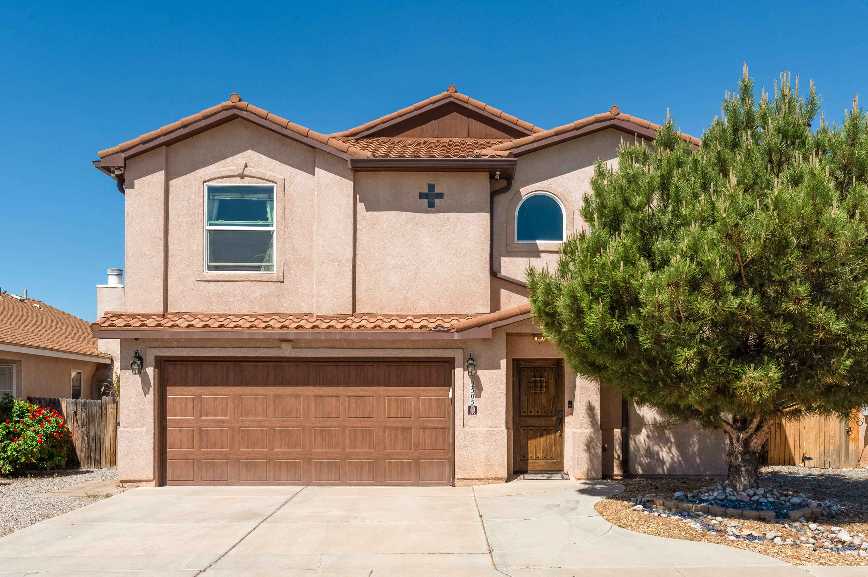 This beautifully designed two-story home blends classic New Mexican and Spanish-style touches with thoughtful modern upgrades. From the smooth plaster walls and high ceilings to the abundance of natural light, every detail has been crafted with care and intention.Fully ADA accessible, the home features a private in-law suite complete with a kitchenette and roll-in- shower. Ideal for guests or multigenerational living. An interior wheel chair lift/ elevator adds comfort and convenience, making both levels easily accessible.The updated kitchen offers generous storage, stainless steel appliances, and elegant finishes that reflect the home's character.  Every detail reflects pride of ownership and quality craftsmanship. This home is truly one of a kind. Virtual Staging Used.