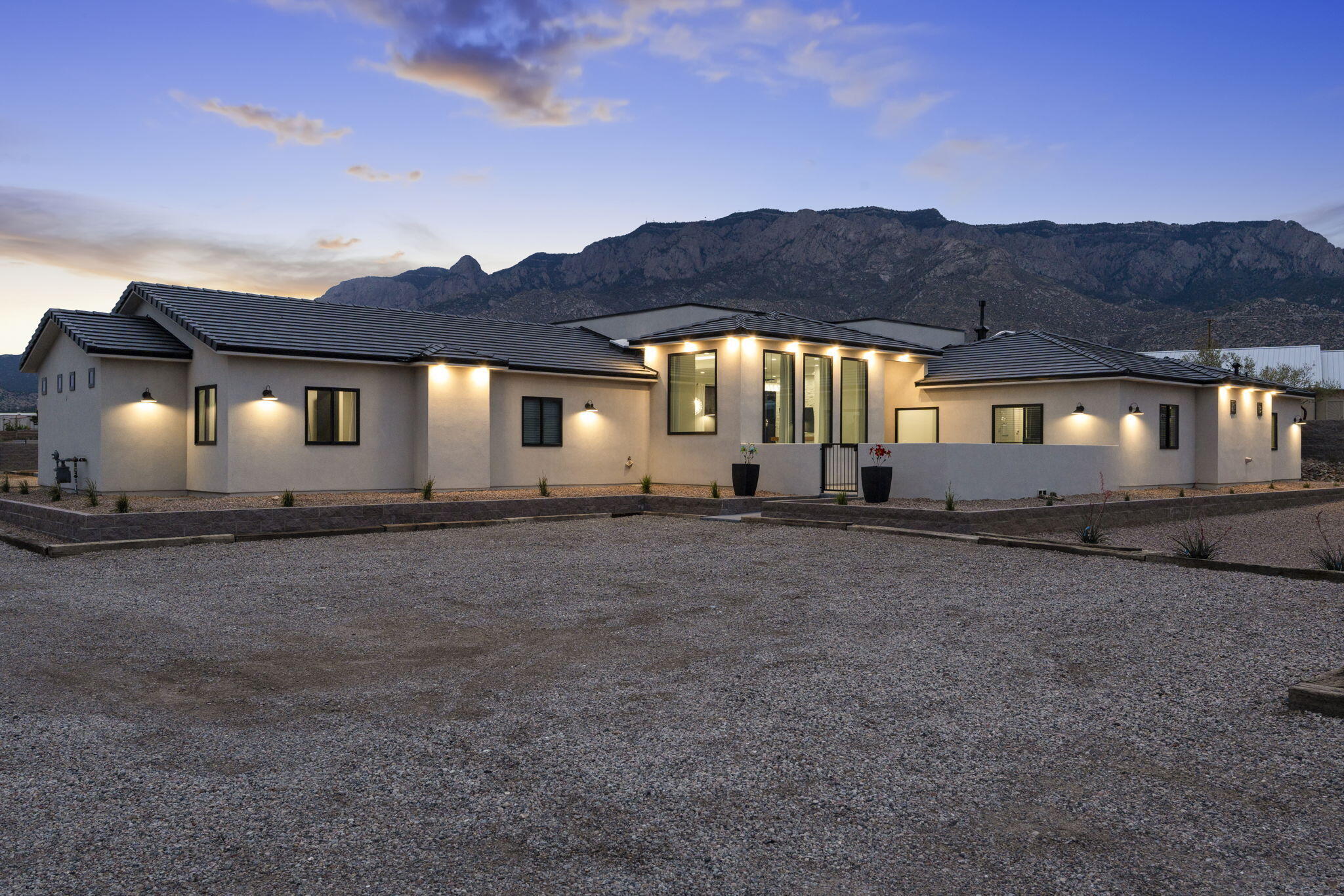 Experience luxury living with stunning Sandia Mountain views in this custom-built home on a .89-acre lot. Featuring 4 bedrooms and 1-bedroom guest house, and premium amenities, this home offers both style and comfort. Enjoy a theater room, gym, office, and upscale finishes, including zoned radiant heat, quartz countertops, custom cabinets, coffered ceilings, and accent lighting. With two fireplaces, ample storage, and an oversized 4-car garage with an EV charging station, every detail has been thoughtfully designed. Step outside to a private oasis with a covered patio, sparkling pool, fenced garden, built-in grill area, and breathtaking views. The property also includes a gated entrance, side and a dedicated dog run with a dog room. Don't miss this one of kind opportunity!