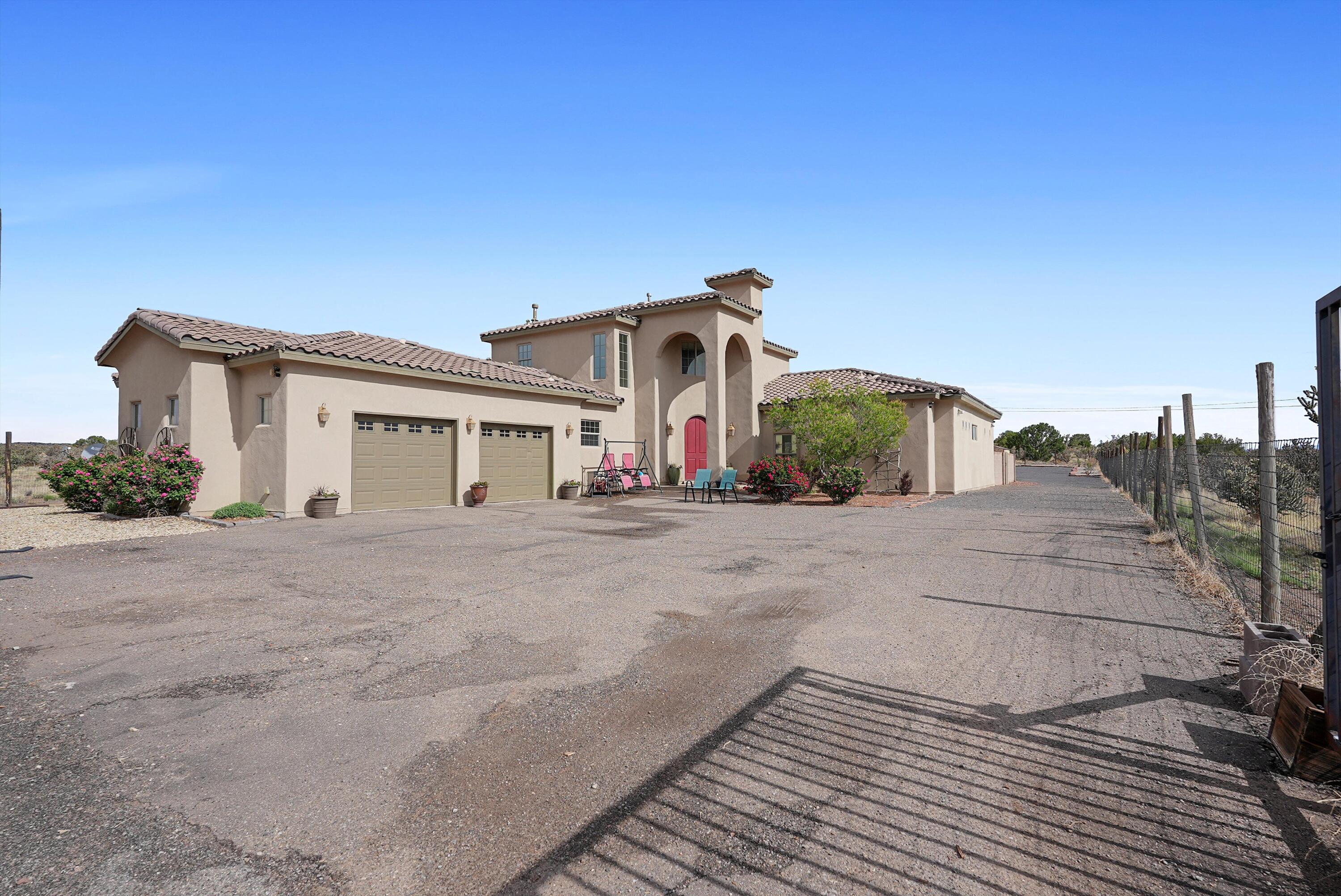 Welcome to this amazing custom home on a half acre lot in Rio Rancho. Gated front entrance for privacy, and beautifully landscaped throughout.  This home features a large open kitchen with abundant storage, a formal dining area, and large family room with gas fireplace.  There's an additional living space that could make for a great den, or large office, playroom or whatever your needs may be.  Primary suite is on the main level for convenience, and offers a luxury bathroom and two walk-in closets.  Upstairs you'll find a loft and two additional bedrooms, as well as an extra laundry room (one on main level too).  New carpet throughout! Home warranty will transfer to new owner, good through July 2030.  Come see this move in ready home today.