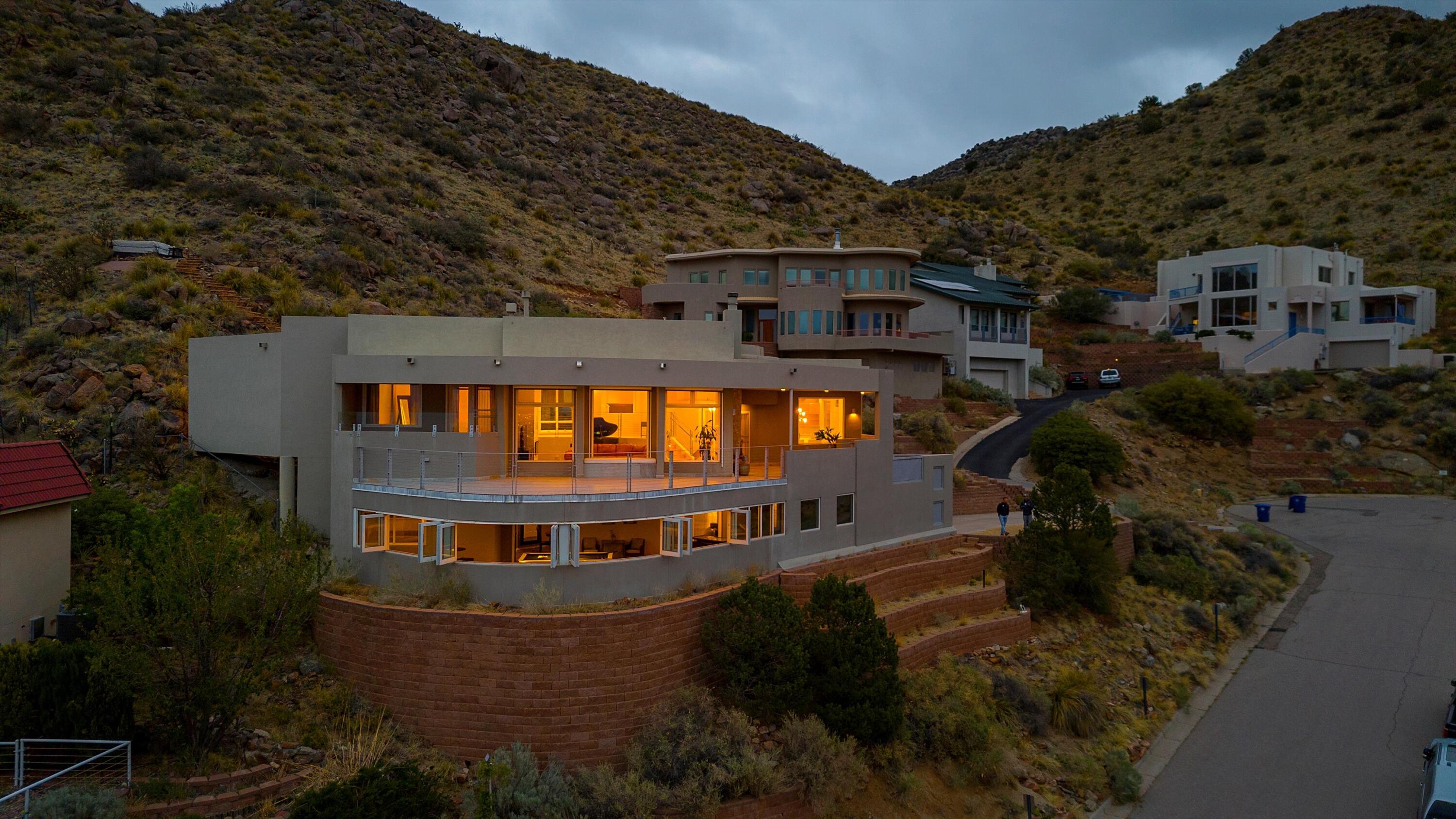 Perched regally at the base of the Sandia Mountains, this extraordinary home--inspired by the timeless beauty and harmony of Native American cliff dwellings--commands one of the most awe-inspiring vistas in all of Albuquerque. Perfectly sited at the end of a serene cul-de-sac, the residence is embraced by open space and the national forest, offering first-class privacy with an ever-changing canvas of panoramic beauty. From glittering city lights below to the rugged grandeur of the mountains above, the views are nothing short of breathtaking.Crafted with uncompromising quality and refined elegance, no detail was spared in bringing this vision to life.