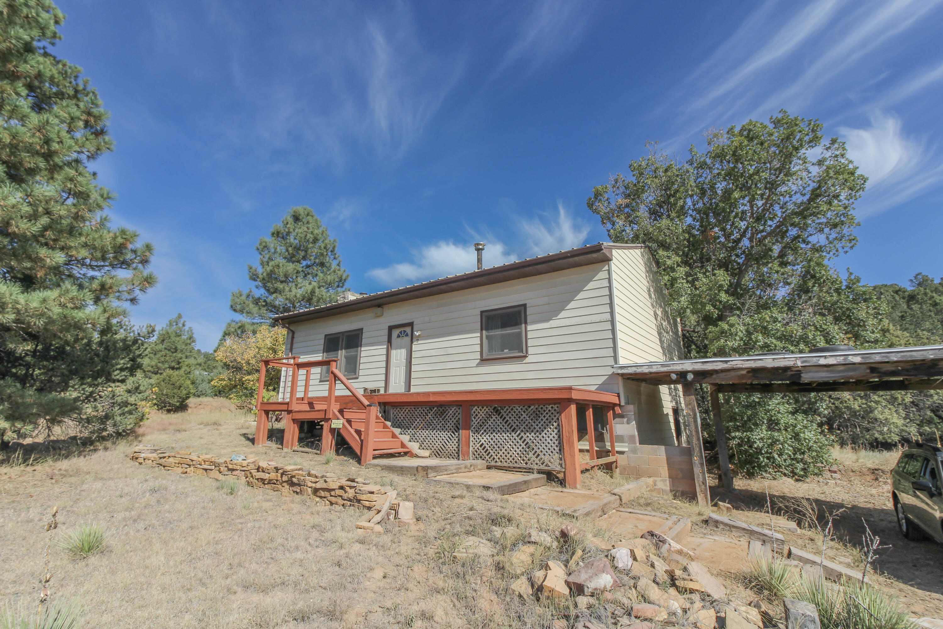 Price just reduced $11,000!  This is a truly unique opportunity to own a piece of Manzano Springs history! This fantastic property is rumored to have been the old clubhouse for Manzano Springs and still has so much of that old charm abounding within it.Original hardwood floors, hand-hewn beams that were brought in from Madrid NM, a large custom wood stove for heat, and an impressive stone faced accent wall that was part of the original fireplace. The 500-gallon propane tank is owned. The nearly 4 acres are made up of 5 individual lots and are accessible from either Ballenger Ranch in the front or Manzano Springs Rd on the side. This home has so much old, rustic charm and personality and would make a wonderful starter home, retirement home,  or vacation home.  The possibilities are endless
