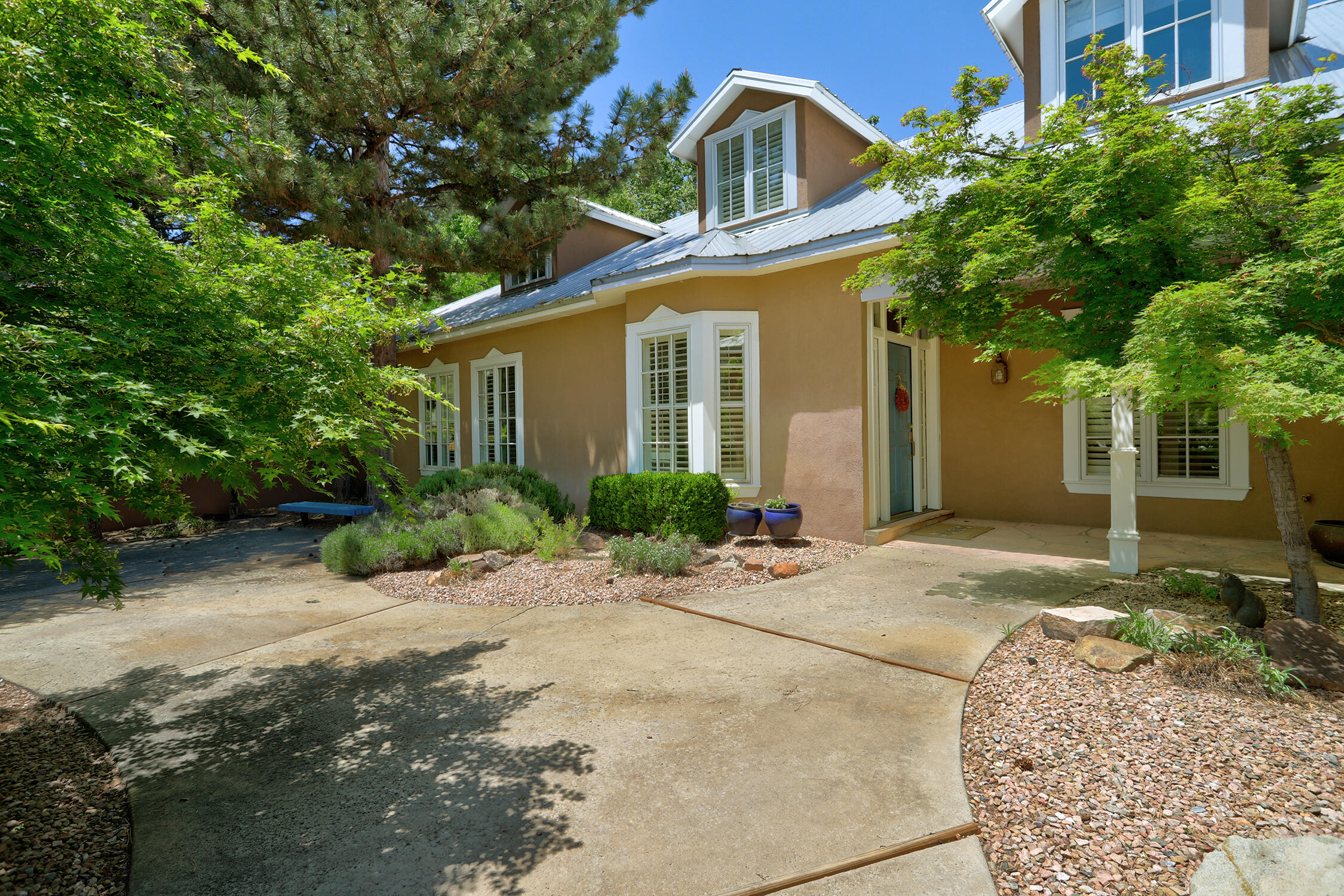 Welcome to the quiet luxury of this northern New Mexican home in the exclusive enclave of Tinnin Farms, situated on a 1.05-acre lot kept lush with the irrigation well. Designed by Eric Spurlock to have room for everyone and outdoor living. On the main level, the remodeled eat-in kitchen has a large walk-in pantry, and french doors to the backyard. The family room has beamed ceilings, a fireplace, and built in shelving. The expansive primary suite has a fireplace and luxury bath with steam shower. French doors to the back patio from the kitchen, family room, and primary suite. Private study, formal living and dining rooms, and wet bar round out the main level. Upstairs, find a second primary suite, living room, two more bedrooms, jack & jill bath, and a gym/office. Gorgeous, livable luxury