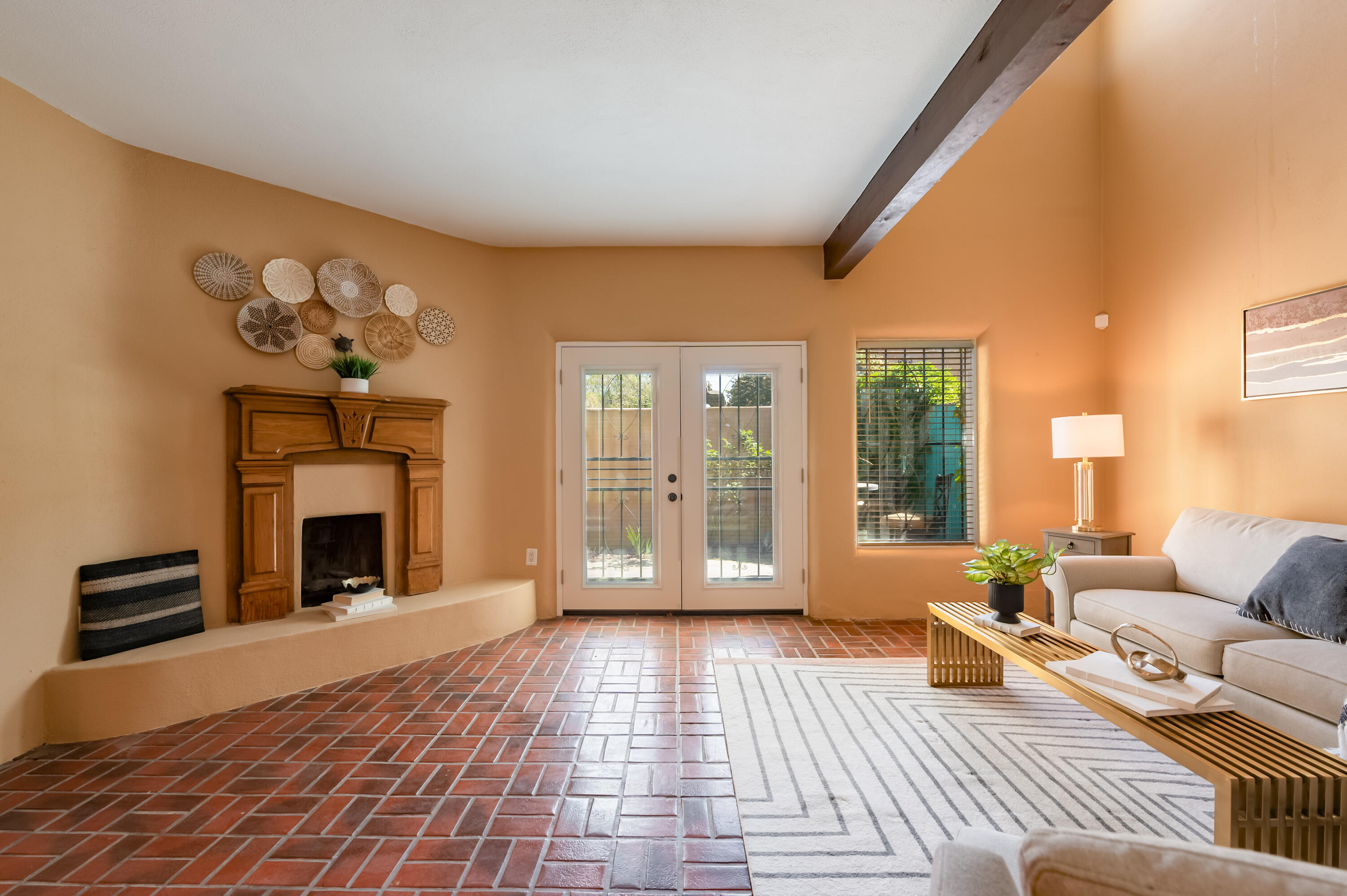 Welcome to a charming conclave of Pueblo homes walking distance to Saw Mill and Old Town and moments from Downtown and UNM. Enter through a charming courtyard Reminiscent of old Santa Fe or New Orleans and into this fun and funky design. Great room with Brick tile floors and attractive custom fireplace on main floor with open dining concept and, efficient kitchen and half bath.  Beautiful wood stairs lead Upstairs where you find updated plank flooring, two bedrooms, one with an updated en-suite bath including granite vanity & updated shower w/barn door glass.  The second bedroom has a loft vibe with access to a spectacular southwest artisan style updated bath. Second story deck to enjoy summer evenings.   Attached 2 car garage.   Refrigerated air.