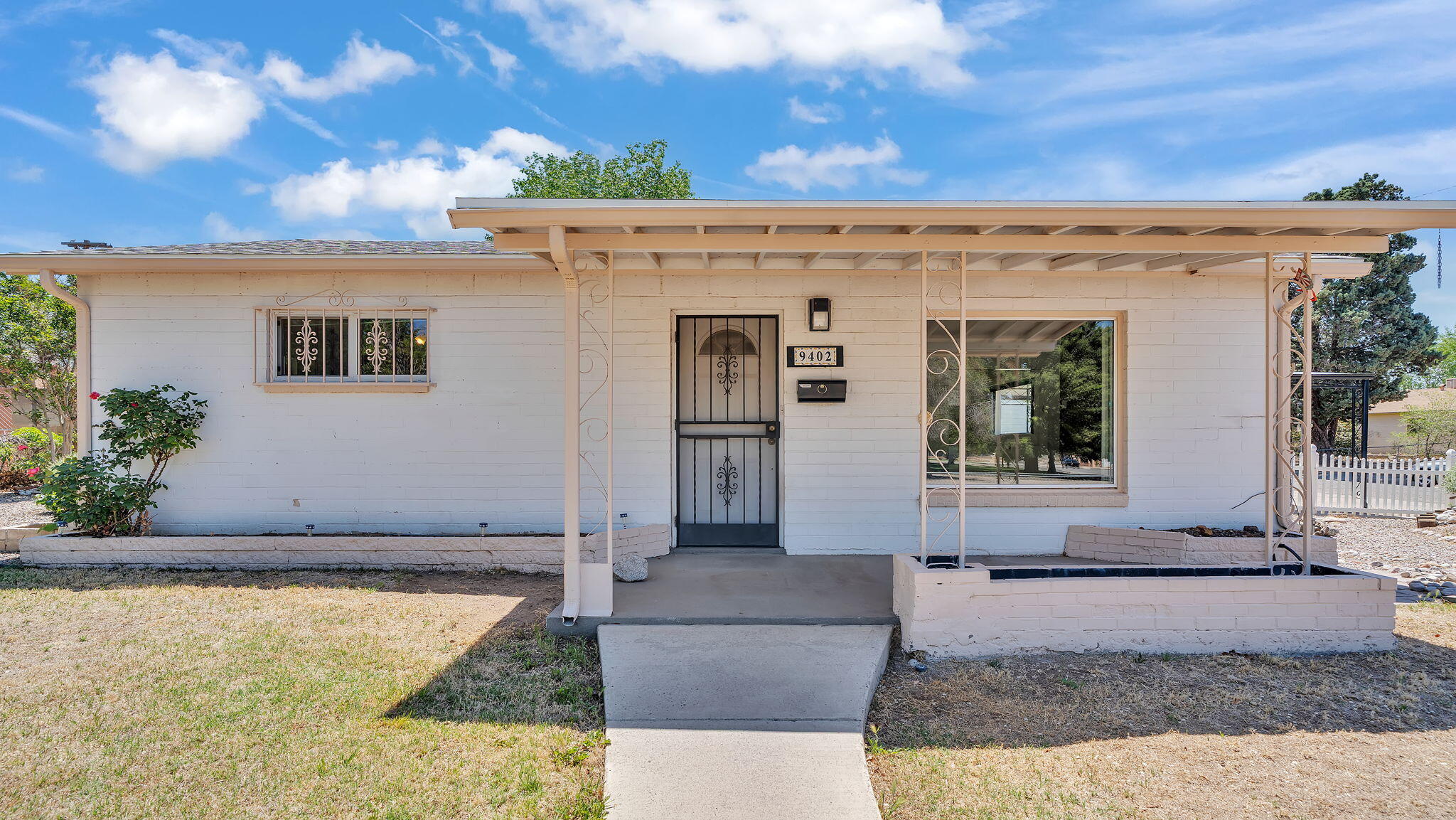 Endless Possibilities on a Spacious Corner Lot!  Discover the potential of this centrally located home, just steps from Conchas Park!  Featuring 2 bedrooms (with the possibility of a third), two living areas, an enclosed back patio leading to a walled-in backyard, this property offers ample space and versatility. Enjoy the convenience of electric washer/dryer hookups, a carport, and two sheds that convey with the home.  With evaporative cooling and a prime location close to shopping, schools, and gyms, this home is a perfect opportunity for your personal touch.  Selling as-is. Inspections are for buyer's knowledge only.