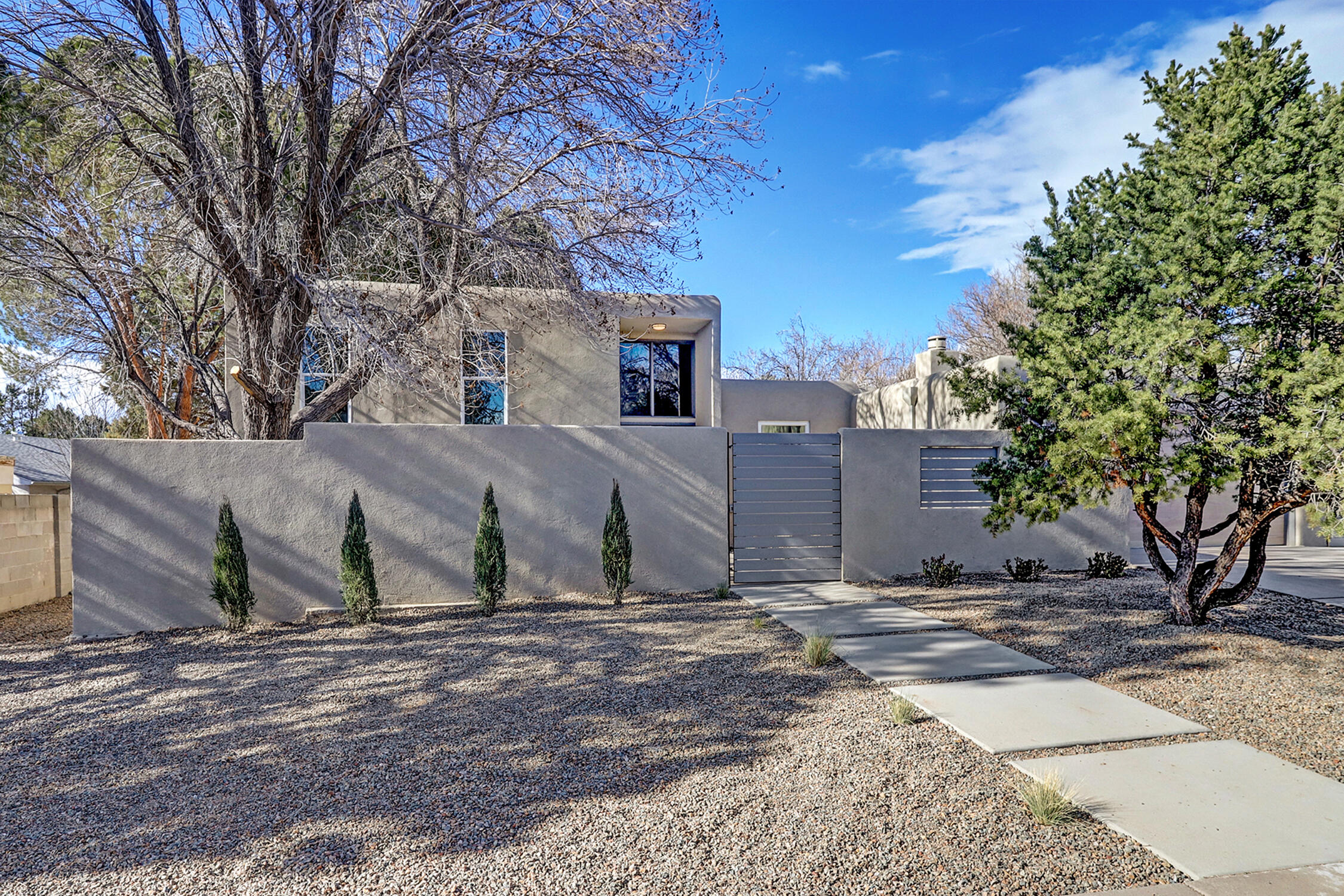 An amazing contemporary split-level home near Arroyo Del Oso Golf Course! 5 bedrooms, 2 living areas both with fireplaces, & a heated pool with an automatic pool cover. Wood look tile floors throughout, & custom tile work in all 3 bathrooms. Kitchen has ample quartz counters, stainless steel appliances, new cabinets & an opulent walk in butler's pantry. Primary suite is a true oasis on its own floor away from the rest of the home. Walk in closet & dressing area that is larger than some bedrooms! Separate tub, & shower with double sinks, make up station & water closet. Bedroom on the main floor with a 3/4 bath. Courtyard entry, with both front & back yards fully landscaped. Refrigerated air, water softener, thermal double pane windows & custom shades with black out in bedrooms.