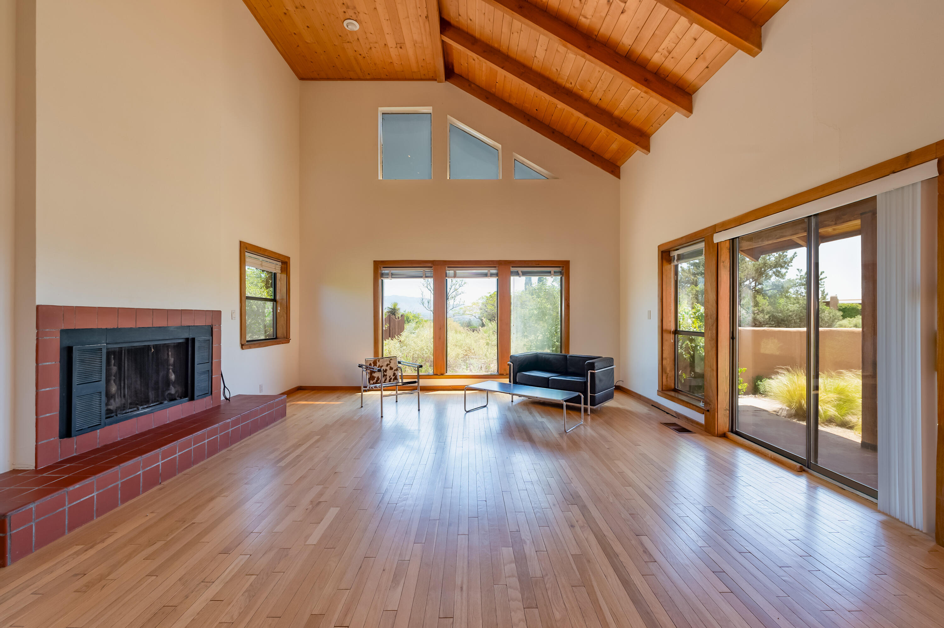 Architect designed home with spacious open floor plan - 2 story great room with gorgeous tongue & groove wood ceiling with wood beams.  This home was previously owned by world renowned architect ANTONIE PREDOCK. The original oak floors throughout are in great condition.  This home is nestled on a quiet cul-de-sac with beautiful views of the city lights and Sandia mountains on .4 acres with an irrigated large back and side lot - perfect for the creative gardener or easy maintenance low water use plantings.  The architect designed, ecologically sustained, fishpond provides a tranquil escape located in the front entry courtyard.  2 large bedrooms on the first floor with a loft/3rd bedroom on the 2nd floor.  The primary suite features an updated bath which includes a separate shower;