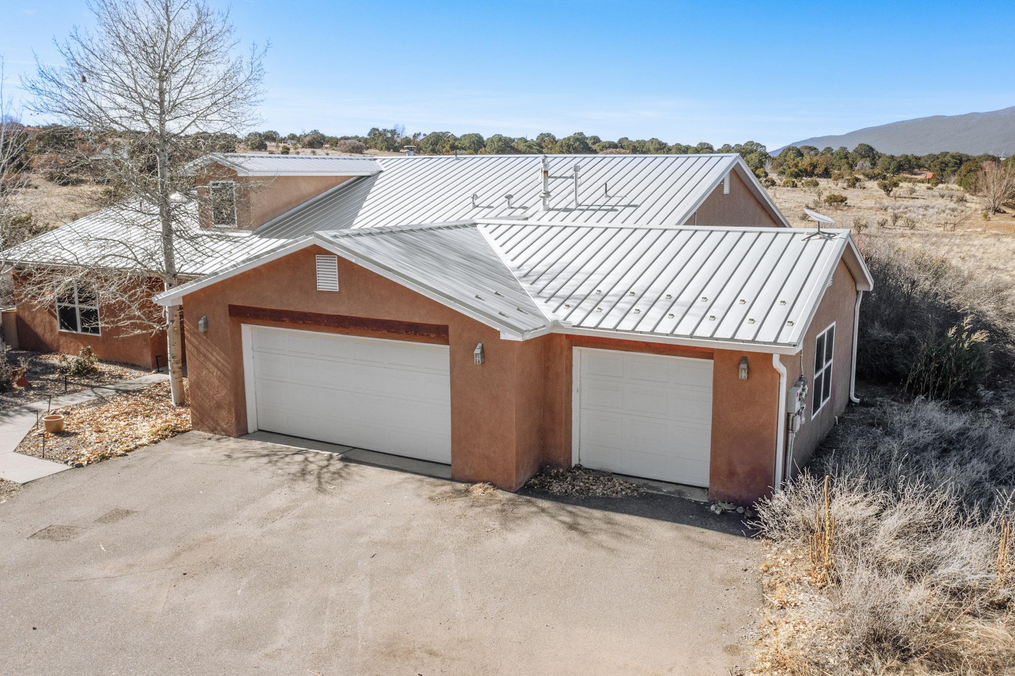 This beautiful home on well over 2 acres features gorgeous views of the Sandia Mountains from the large, covered back patio. On it's own private drive-providing quiet, country living at it's finest. Gorgeous inside and out, interior features 3 bedrooms, 2 full baths plus an oversized 3 car garage. Wonderful kitchen offers beautiful granite counter tops, gas stove, built in microwave, stainless steel fridge that conveys with home, pantry, beautiful tile plus breakfast nook. Large Living Room with cozy, wood burning kiva fireplace and plenty of windows. Very generous Primary Bedroom with bathroom offering double sink vanity, garden tub and separate shower. Solar System, metal roof. Washer and dryer stay. Satellite dish already installed with Starlink for great internet service.