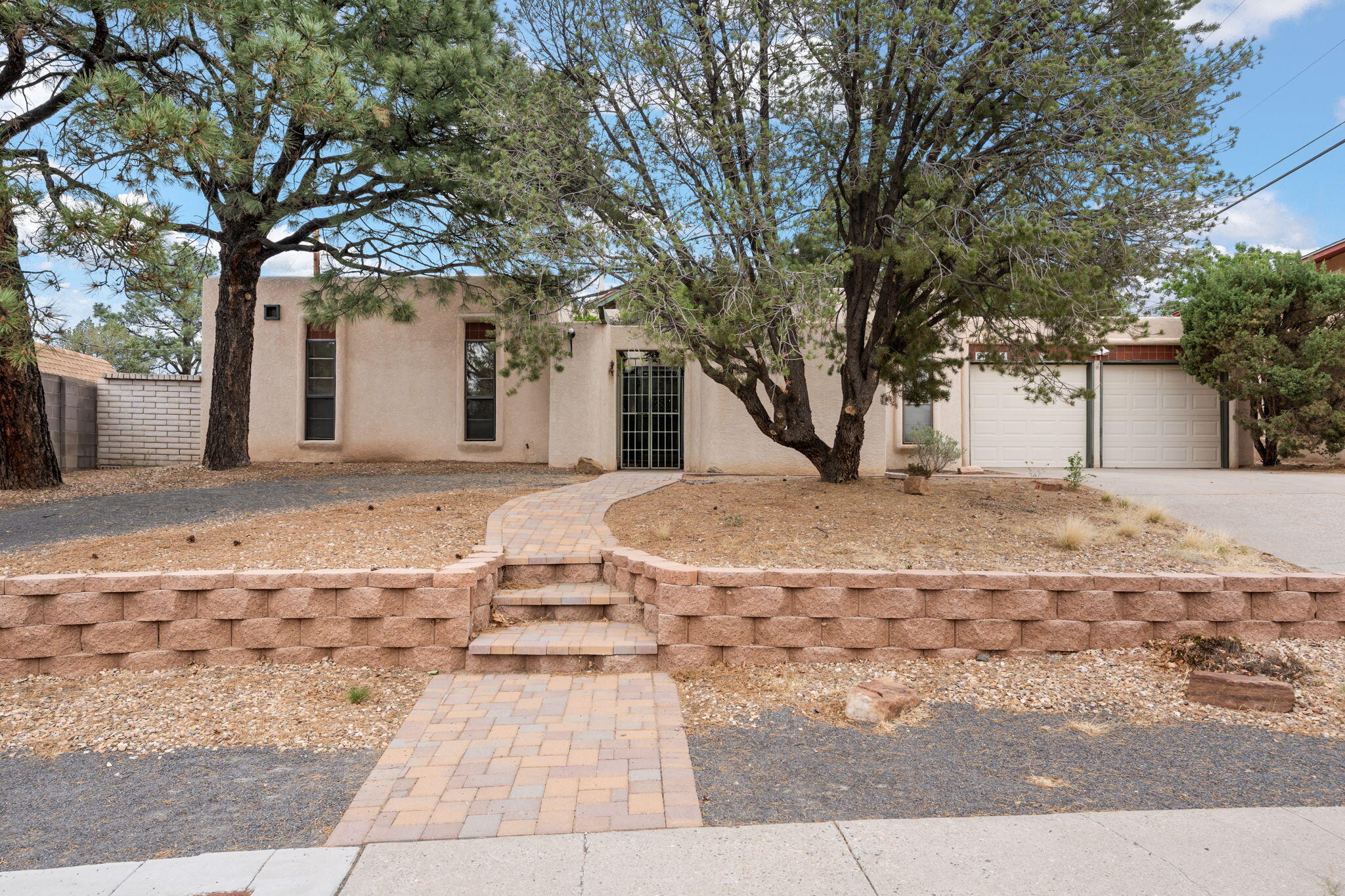 This NE Heights home offers ~2,220sf, plus a sunroom ~325sf with 2024 flooring. Inside, you'll find 4 bedrooms, 3 baths, two living areas, and a flexible layout. Skylights and generous natural light throughout. Separate living space near the garage adds options for privacy or guests. Updates include refrigerated air (less than 5 years old), paid-off solar (2016), two furnaces, two water heaters, and some newer kitchen appliances. The primary suite includes an accessible shower with dual shower heads, and additional storage is available in the Tuff Shed and garage closet. Enjoy a small, covered courtyard entry. Near to Loma del Rey Park. Deep cleaned and cared for, this home is offered as-is and priced with room to make it your own. Schedule a tour and see for yourself!