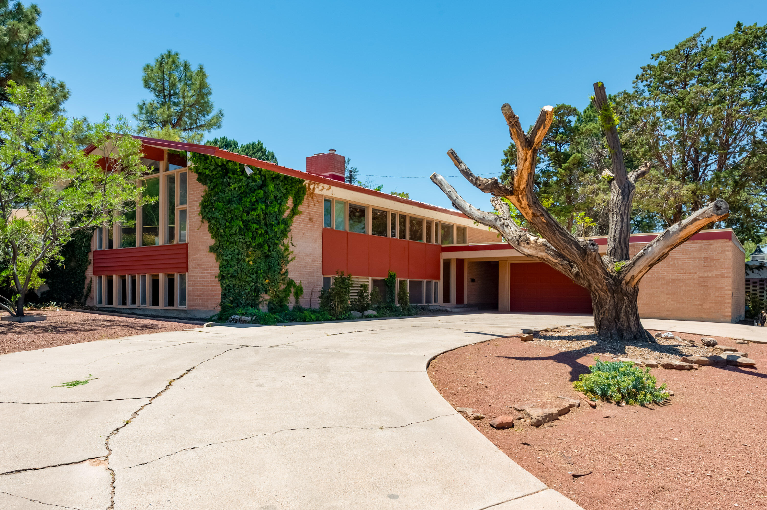 Step into this mid-century modern split-level home where a full wall of windows frames breathtaking mountain views. Two separate living areas--a bright, open lounge anchored by a two way fireplace fireplace and a Living space great for entertaining with doors out to the private backyard with mature vegetation. Spacious bedrooms and tons of storage spaces offer amble room. The primary suite offers a soaking tub, separate shower and double sinks, plus custom wood closeting. Move in ready with a new roof and evap cooler!