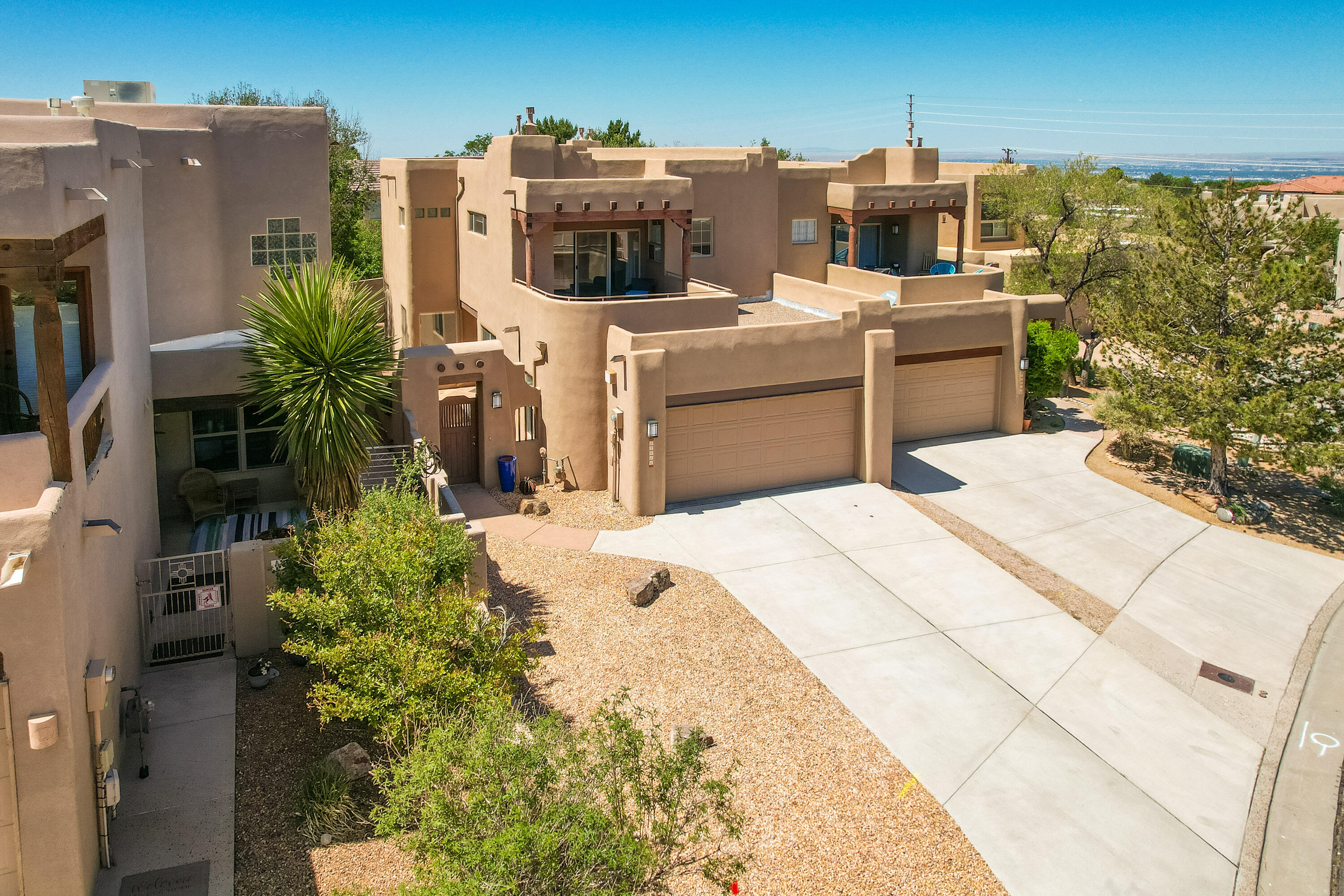 This High Desert townhouse is light &  bright w/ a functional open floor plan.  Enter home through a private courtyard gate.  The large living room has soaring ceilings w/ a stacked stone fireplace, wood accents & enough room for 2 sitting areas.  Primary bedroom features large, walk in closet, separate bath & shower plus 2 sink areas.  It also has a sizable balcony w/ great views of the Sandias! Updated tile flooring, bathrooms & LED lighting throughout. Huge windows in LR - 2 have motorized blinds to help control temp.   Newer stainless oven, microwave & dishwasher. Newer water heater & furnace.  Location makes it an easy commute to most places in ABQ & offers easy access to both freeways.  Closed to foothill trails & High Desert park w/ both tennis courts & playground.