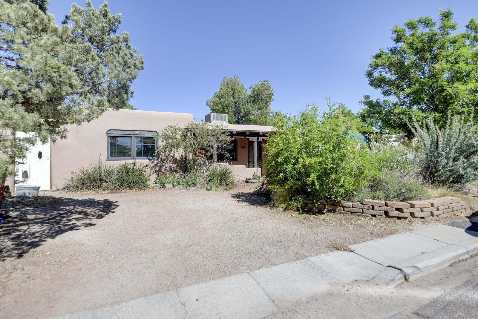 A rare opportunity to make this authentic Watson adobe in a wonderful location your next home! This 3 bedroom/2 bath home combines signature details (kiva fireplaces, vigas, tile floors) with a modern updated kitchen, refrigerated air, insulated pocket roof, and a separate heated/cooled studio space with separate entrances from both the back and side yards. Natural southwest landscape front and back. Blocks from Tiguex Park, Old Town, museums, the Biopark, the Sawmill District, plus shops and restaurants galore! Homes are rarely available in this quiet, established, and historic neighborhood - you don't want to miss this!