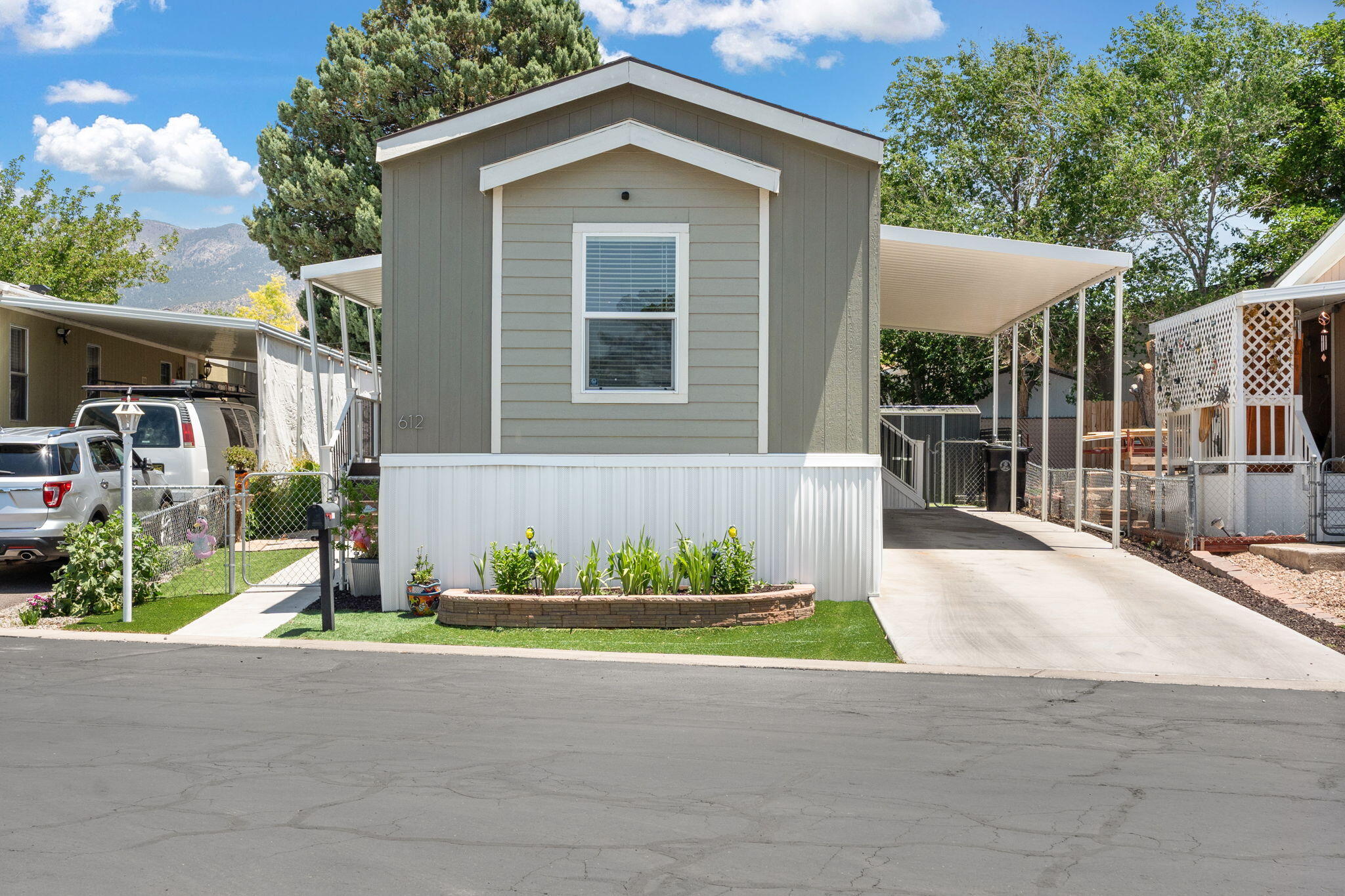 Welcome to this beautifully appointed 2021 home in Four Hills Mobile Home Park! Step onto the covered porch and into a spacious, open layout featuring decorative ceiling beams, corner shelving, and an electric fireplace in the living room. The kitchen shines with stainless steel appliances and flows seamlessly for entertaining. The primary suite offers a garden tub, separate shower, and plenty of space to unwind. Outdoors, enjoy a custom landscape with turf, flagstone, an outdoor theater, kitchen, shed, and even a dog yard with a custom doghouse. Community perks include trails, parks, pools, a store, and security.