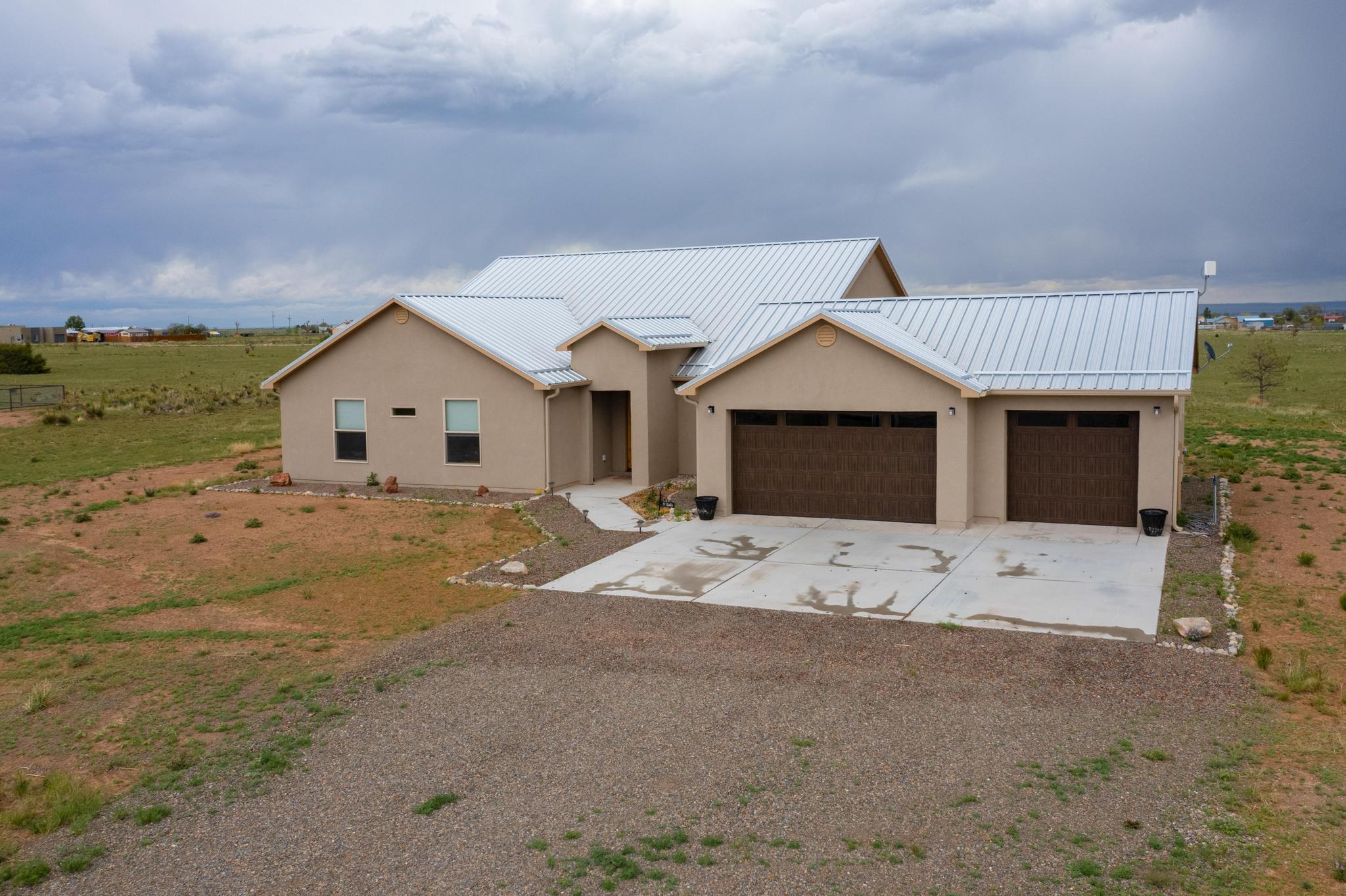 This home seamlessly blends a contemporary style with the perks and adventures that come with rural living!! This stunning home puts pride of ownership on full display.  Built in 2023, this custom home boasts upgrades that complement a bright, light, warm, welcoming environment and wide open spaces.  The home offers a metal roof, 3 car garage, custom wood cabinets, owned water softener, granite countertops in the kitchen, Quartz countertops in the bathrooms and laundry room, a tank-less water heater and stainless steel appliances. The laundry room provides an incredible amount of space for convenience, storage and comfort.  Keep the living room warm in the winters with the beautiful gas log fireplace, limestone veneer and stylish mantle.  Fully fenced backyard for the animals to run!