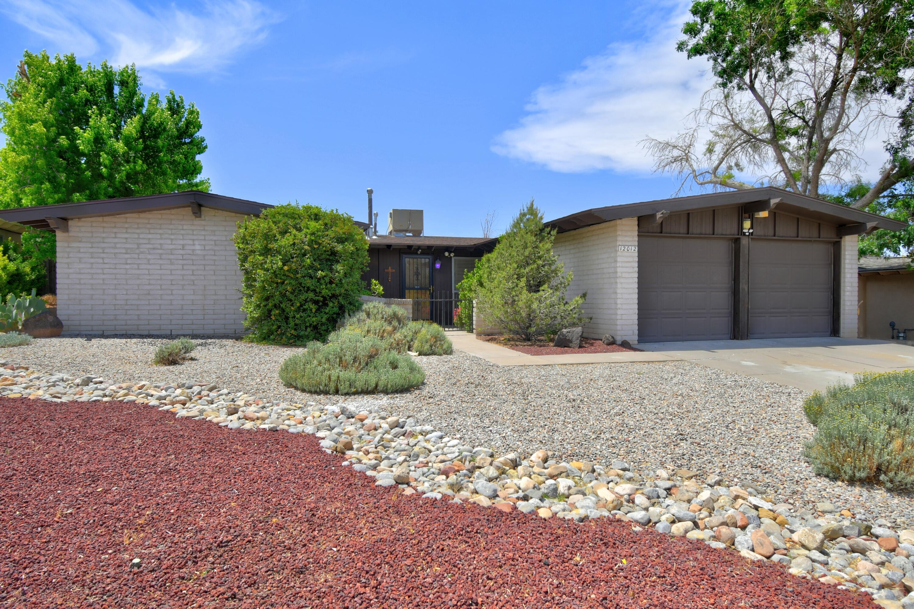 Step out the front door of this one owner home into a classic Spanish courtyard with breath taking views of Manzano and Sandia Mountains. This 1968 mid-century home awaits you with classic tile in the entry and wooden beams in the spacious living area. A beautiful functional fireplace for crisp NM nights. Kitchen displays custom hand carved cabinets with built-in double oven. All appliances convey. Double paned windows throughout for energy efficiency. Newer roof (2022), new furnace & water heater, carpet replaced throughout (2024). Large master bedroom with a retreat area and built in floor safe. Walk through a glass enclosed heated patio to a 6 ft deep swimming pool. This won't last long, call for your appointment today!