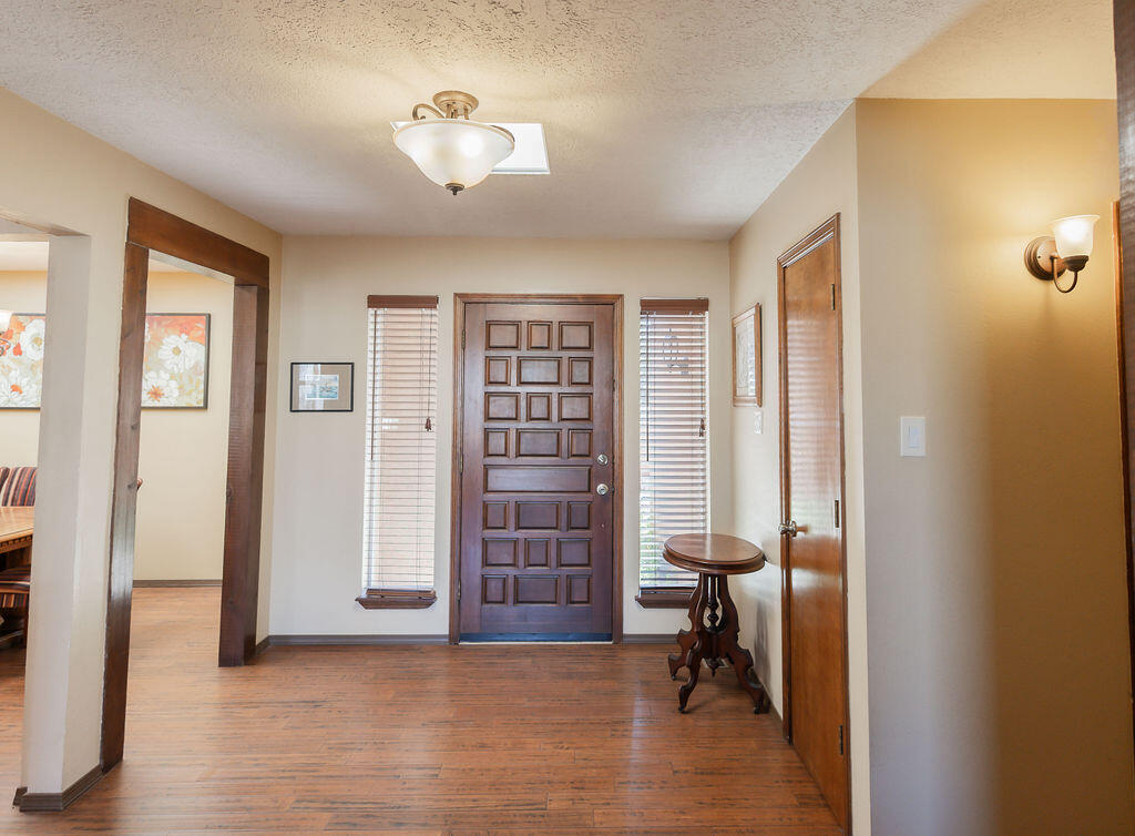 Stunning New Mexico-Style Home with Modern Touches and Spectacular Mountain Views!Step into Southwest charm and contemporary comfort in this beautifully updated 3-bedroom, 2-bath home. A private courtyard entry sets the tone, leading into a light-filled interior with dramatic wood-beamed ceilings, bamboo flooring, and a classic kiva fireplace that anchors the living space. The thoughtfully designed kitchen features sleek Corian countertops, stainless steel appliances, and modern cabinetry--perfect for both everyday living and entertaining. The spacious primary suite offers a tranquil retreat with a built-in window bench, barn door entry, and a stylishly remodeled en-suite bath. Enjoy year-round comfort with new windows and recently installed refrigerated air. Located just around