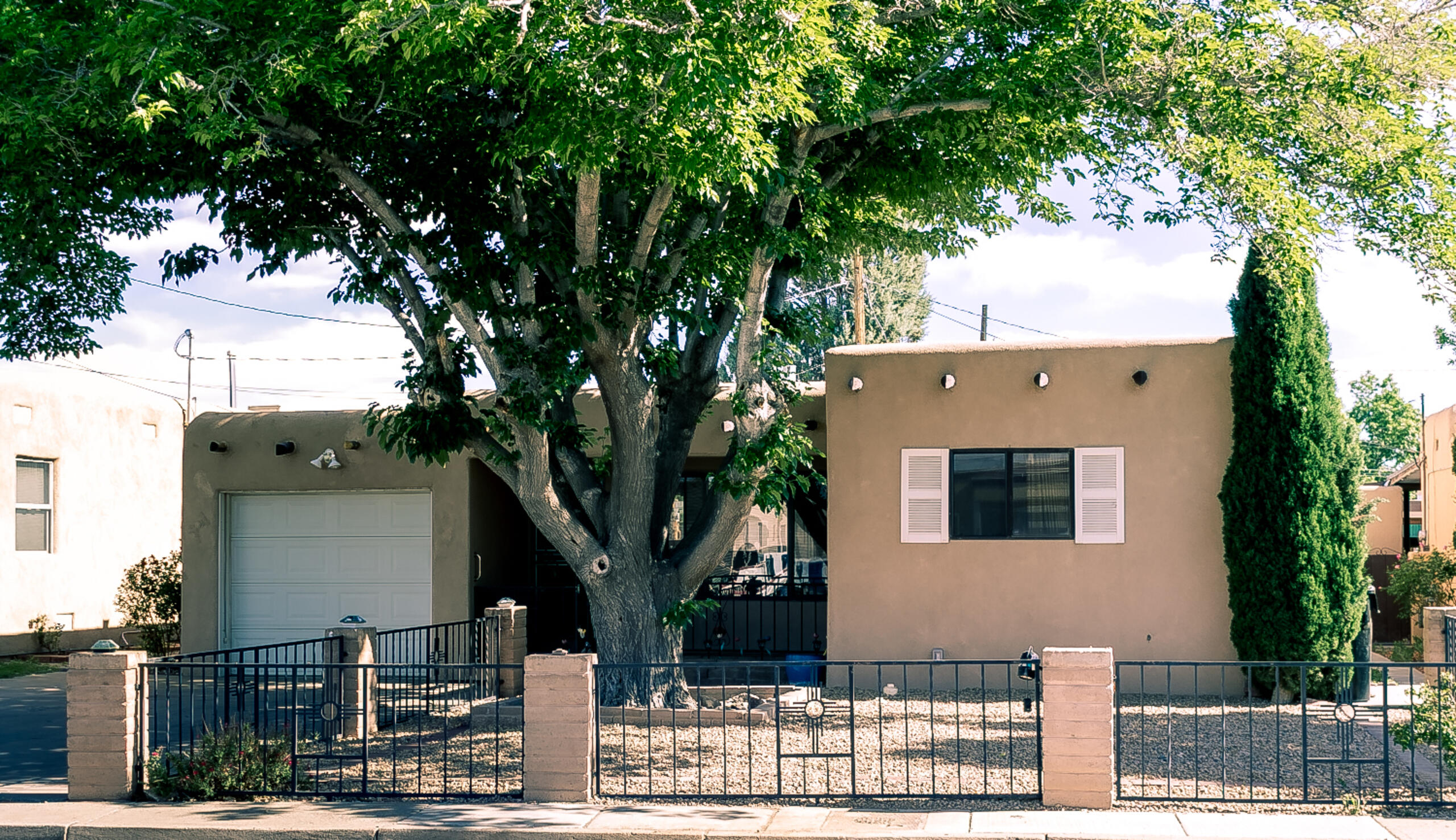One level home in Near North Valley with three living areas, three bedrooms & 2.5 baths! Kitchen with pantry, laundry area & new electric range/oven (May 25). Fridge/washer/dryer all convey. New electrical service panel (May 2025). New water heater (May 2025). Sewer line new in 2022. Red oak hardwood floors in original part of home. Coved ceiling. Ceiling fans. Cedar closet. Family room has gaslog fireplace; sunroom has gas stove for warmth & ambience. Gated front porch + beautiful oversized pergola over tile in back. 2nd covered patio + Morgan building + barn with electrical service (workshop/main level & storage/upper level). Easy-care gravel in front + lawn in back. One car garage with opener. A lot of square footage and value for the price!