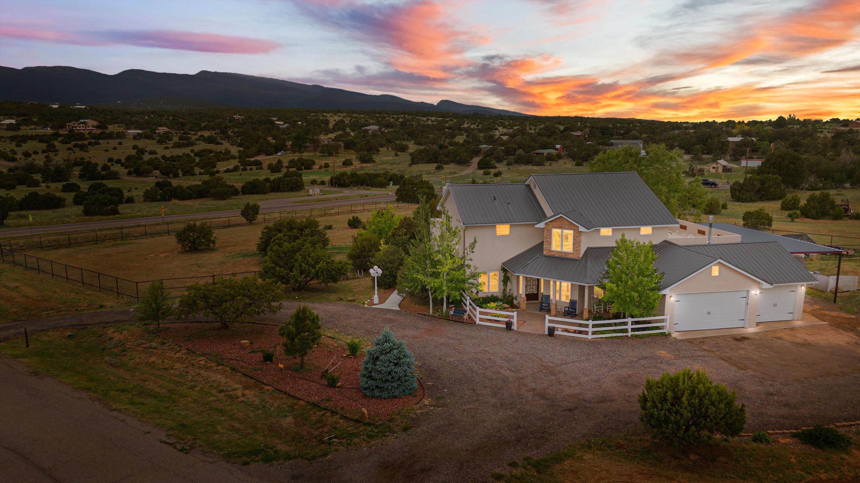 IN THE TRANQUIL MOUNTAINS OF TIJERAS--152 ELITE DRIVE OFFERS SPACE, PEACE, AND VIEWS YOU'LL NEVER WANT TO LEAVE. This stunning 4-bedroom, 4-bath home sits on 3 private acres surrounded by forested beauty and open skies. Beam ceilings and light-filled windows frame an open interior that flows to an upper deck with panoramic views. The property boasts a large carport, RV metal canopy, basketball court and horse fencing for equestrian pursuits. Inside, newer carpet, updated plumbing, twin tankless water heaters, reverse osmosis, an Echo water softener and two pellet stoves provide comfort and convenience. Dual combo refrigeration and central heater units, fiber-optic WiFi and a 3-car garage add modern ease. Live where nature is your neighbor and every day feels like a getaway!
