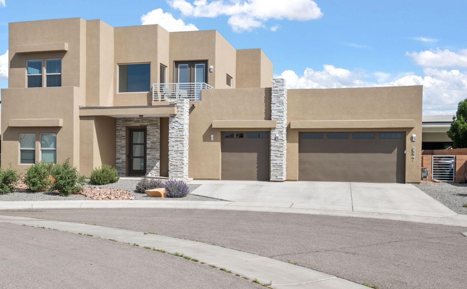 Stunning home in the sought-after Petroglyph Estates! Featuring 5 spacious bedrooms, 4.5 baths, 2 living areas, and a 3-car garage. The primary suite and in-law area are conveniently located on the main floor. Beautiful high-end tile, 10' ceilings, massive sliding glass doors, iron stair railing, and a gorgeous tiled fireplace highlight the space. The chef's kitchen boasts custom cabinetry, high end appliances, a waterfall Quartz island, elegant lighting, and a walk-in pantry with a butler's area. Large primary bedroom with private door to the backyard and gorgeous bathroom with soaker tub and custom tile. Large second living space upstairs with 3 bedrooms and a balcony and views. Quiet street with no through traffic!
