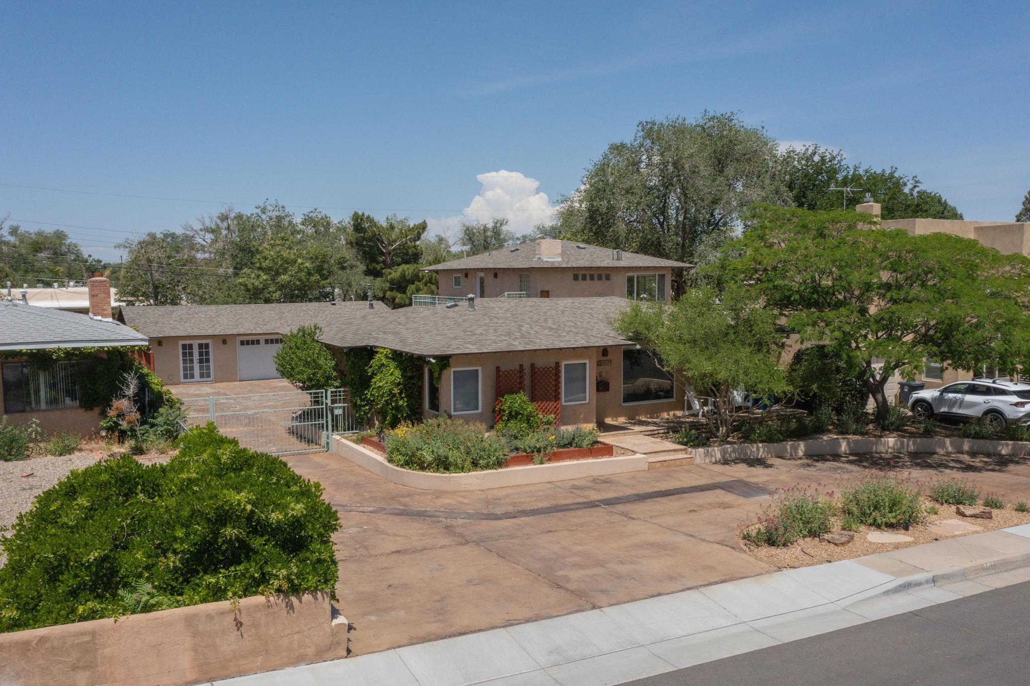 Amazing location in the heart of Ridgecrest/ Nob Hill Neighborhoods.  Close to Sandia Labs, Air Force Base, UNM, CNM and the wonderful dining options of Nob Hill. This gorgeous property has Two Master Bedrooms, one upstairs and one downstairs along with an 1,018 sq. ft. Attached Guest House/ Casita with separate entrance for multi-generational living & more! The finished, heated garage with A/C makes a great space for car lovers, exercise yoga studio, hobby room, or office with a flexible indoor/outdoor space. The historic neighborhood has a greenbelt along Ridgecrest Drive which is ideal for walking,  jogging or strolls with your pets. Granite countertops, stainless steel appliances, custom paint treatments, wood & tile floors, and an outdoor kitchen & fireplace in the private courtyard.