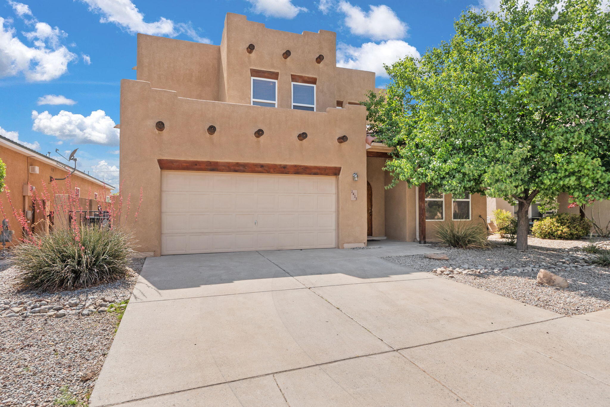 Located in the desirable gated community of Symphony, this beautifully maintained Pueblo-style home offers a perfect blend of Southwestern charm and modern comfort. The thoughtfully designed floor plan features the primary suite conveniently located on the main floor, with three additional bedrooms and a spacious loft upstairs. Enjoy the open-concept living area, perfect for today's lifestyle, complete with soaring 9 and 11 foot ceilings, exposed vigas, and a cozy kiva fireplace. The kitchen boasts solid surface countertops, a built-in microwave, and ample space for entertaining. Step outside to a covered patio and easy maintenance backyard. Recent updates include a brand-new roof, brand-new carpet, and newer laminate flooring. The home is just minutes from lots of North Valley amenities!