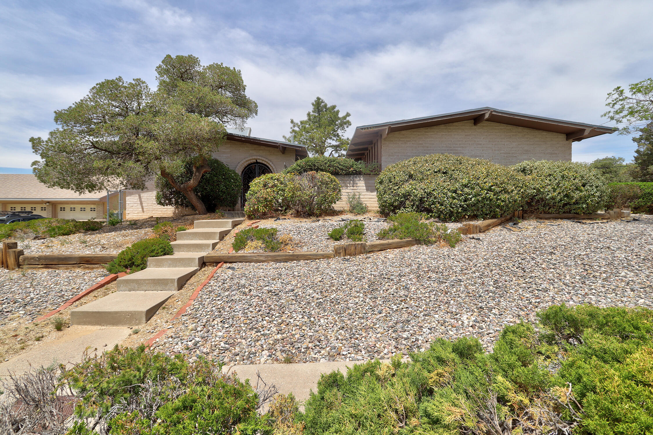 This charming mid-century ranch sits on a spacious corner lot and is ready for your personal touch! Original built-ins, wrought iron decorative accents, wood beams and avocado kitchen that add timeless character. This home offers the prefect blend of vintage charm and opportunity for your modern updates. Two living areas with vaulted ceilings, one with a fireplace that opens to the backyard with a covered patio and a pool to enjoy on those hot summer days. The primary suite has a walk in closet and a large bathroom to reimagine into your dream bath. There are mountain views and back yard access all on .28 of an acre. The two car garage and driveway face Hiawatha. This part of Constitution is East of Juan Tabo and is considered a residential street. All appliances convey.