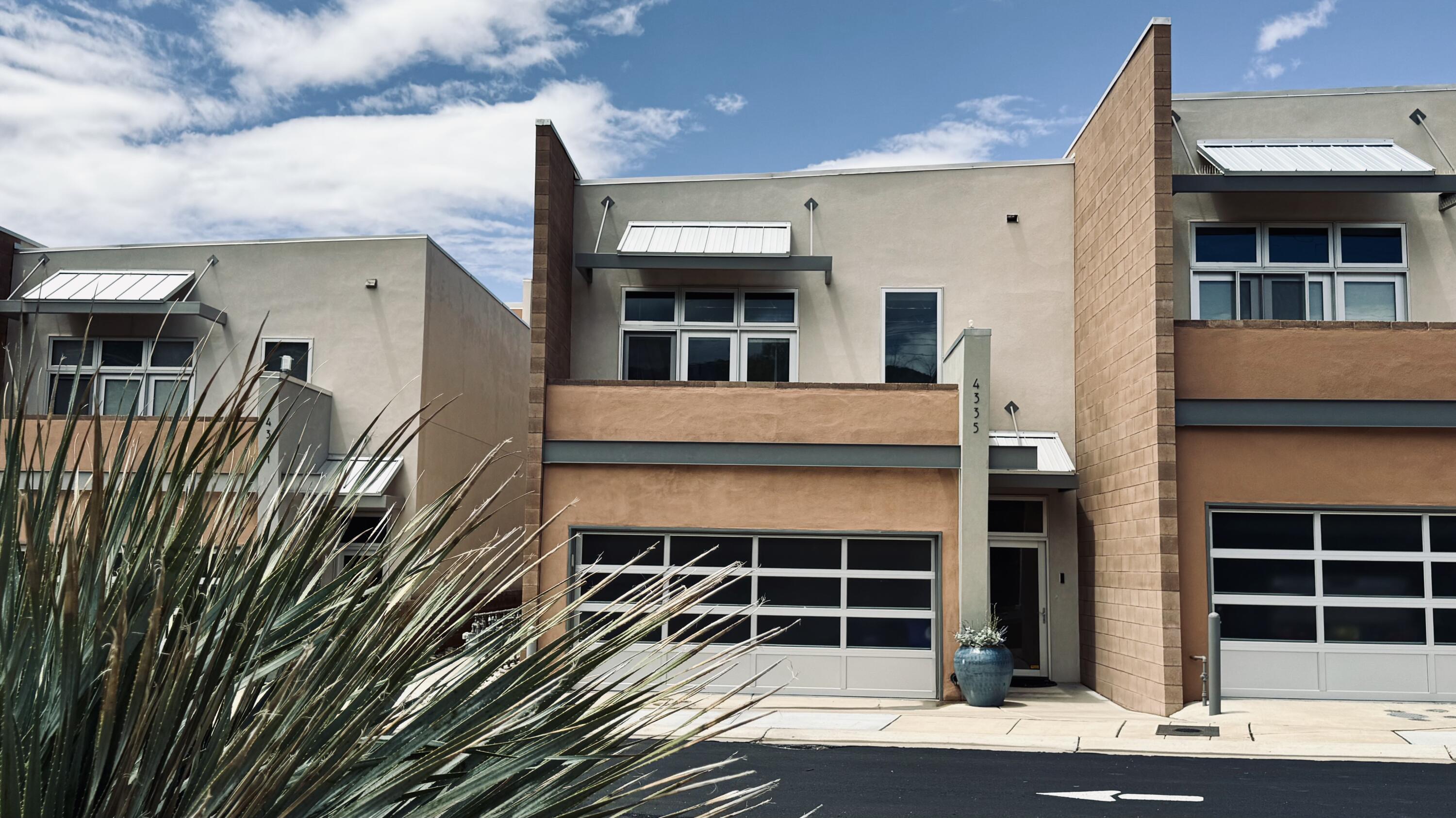 Gated 2108 sq ft, 2BD/2.5BA townhome with modern industrial design--aluminum garage doors, masonry walls, exposed beams, ductwork, and stained concrete floors with radiant heat, plus forced air and AC. Downstairs features kitchen with island, stainless appliances, dining room with built-ins, gas fireplace, laundry, half bath, and 2-car garage with storage. Open-concept living flows to a private walled courtyard. Upstairs: wood floors, oversized primary suite with balcony and mountain views, built-in desk, dual walk-in closets, tiled shower. 2nd bedroom and full bath plus ~130 sq ft loft. Near trails, dining, and shopping.