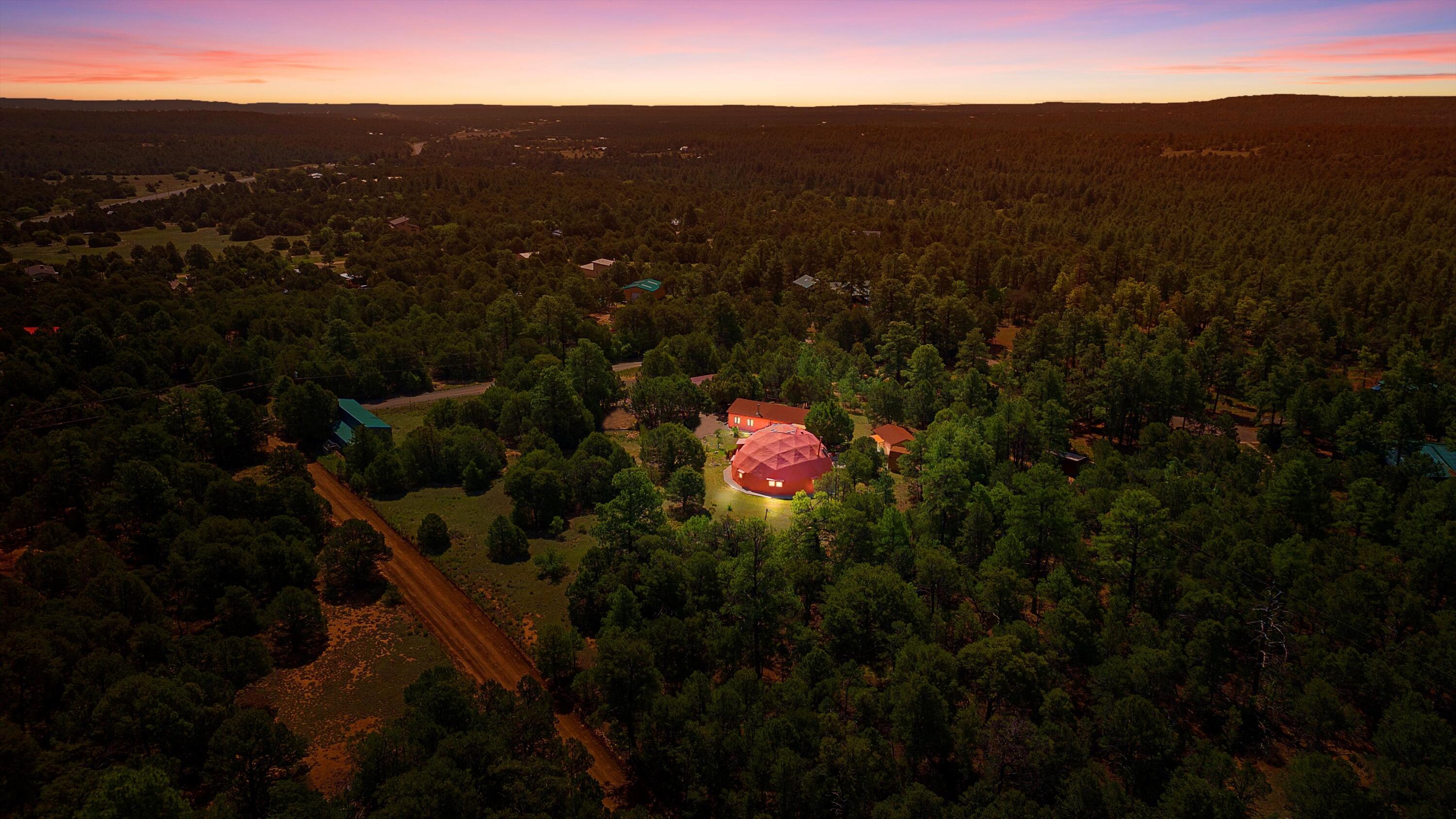UNLIKE ANYTHING ELSE IN THE EAST MOUNTAINS, THIS EXPANSIVE TIJERAS HORSE PROPERTY IS A WORLD OF ITS OWN. Tucked into over four wooded and meadowed acres, it offers a rare blend of space, privacy, and versatility with three distinct residences. The 2-story dome house features exposed beams, tile floors, two fireplaces, and a charming country kitchen. Imagine sitting out on the open patio with 360 degrees of nature.  The cozy casita is a perfect studio or guest house, while the spacious cottage--with its open layout, concrete floors, wood stove, and walk-in closet--adds even more flexibility for multi-generational living. A pole barn, detached garage, workshop, plenty of room of animals and toys. Furniture and tools convey--bring your vision and make this one your perfect mountain retreat!