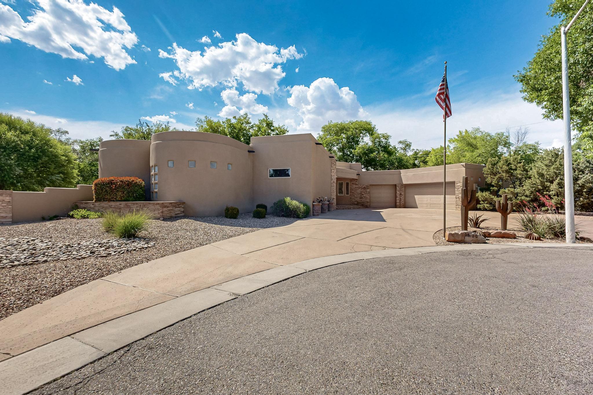 Stunning Eric Spurlock design in Albuquerque's prestigious North Valley, nestled at the end of a private cul-de-sac with private gate access to the walking trail along the Duranes Lateral. This luxury home boasts 12' ceilings, refrigerated and humidified air, recirculating softened water, and a solar-owned system. The primary suite includes a fireplace, flex space, and a spa-like ensuite with a walk-in shower for two, his/her commodes, and a bidet. Entertain in style from intimate gatherings to large parties. The open floor plan creates a seamless transition to the game room with wet bar, ice maker, and mini fridge or outdoors to the expansive covered patio, grill, fireplace and putting green. Backyard gate access to the ditch walking path. RV parking possible, and a cooled, 4-car garage.