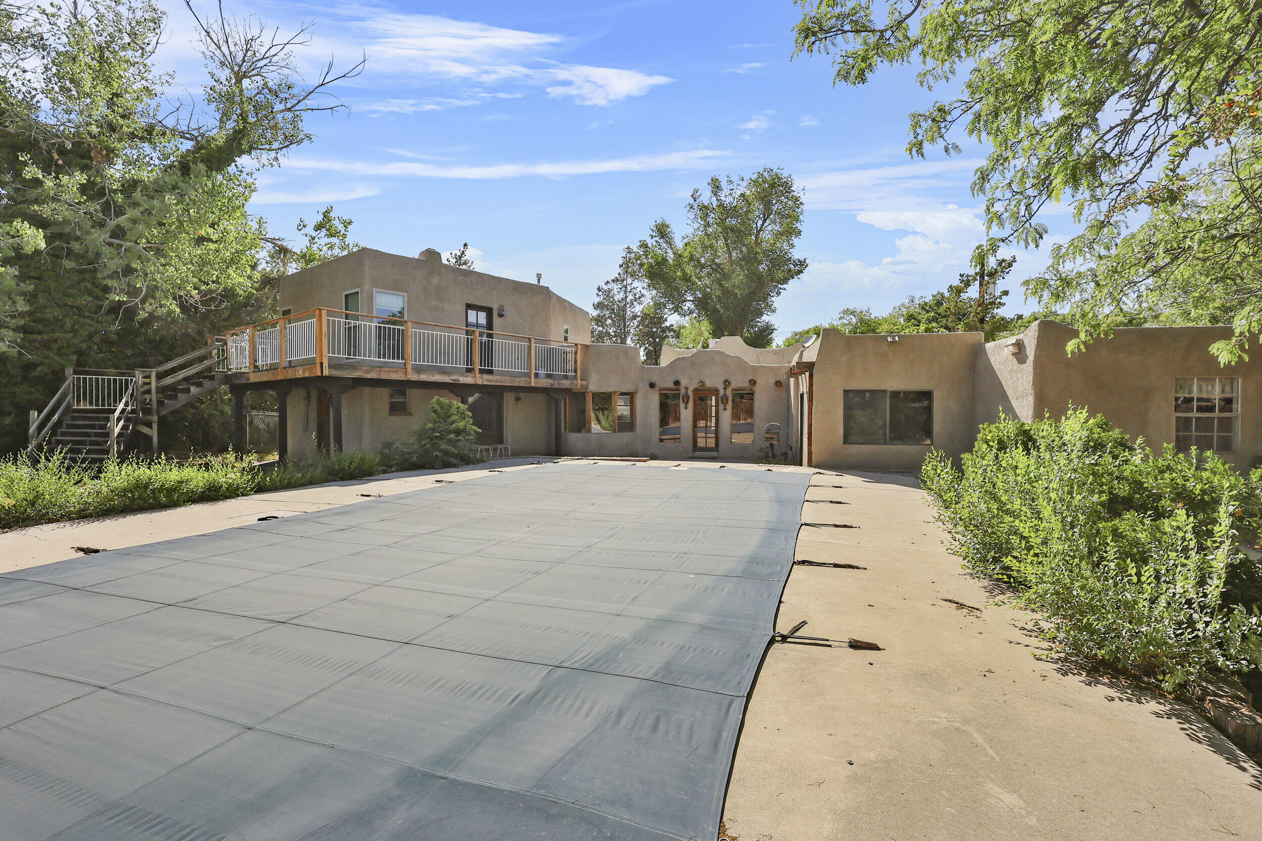 This unique Southwest-style property blends charm, space, and flexibility for living, working, or running a home-based business. Zoned residential/agricultural, it's ideal for self-sustaining living--perfect for animals, gardens, and more--while offering city convenience. Inside features viga fireplaces, rustic beams, brick floors, and Spanish-style lighting. The spacious layout includes formal and family rooms, an updated kitchen with granite counters and stainless appliances, and a private primary suite. Outdoors: pool, hot tub, deck with city/mountain views, and 13 parking spaces including a Quonset hut for an RV. Extras: city water, private well, wood shed, and endless potential.Ask your agent for the detailed marketing description! Don't miss this opportunity!