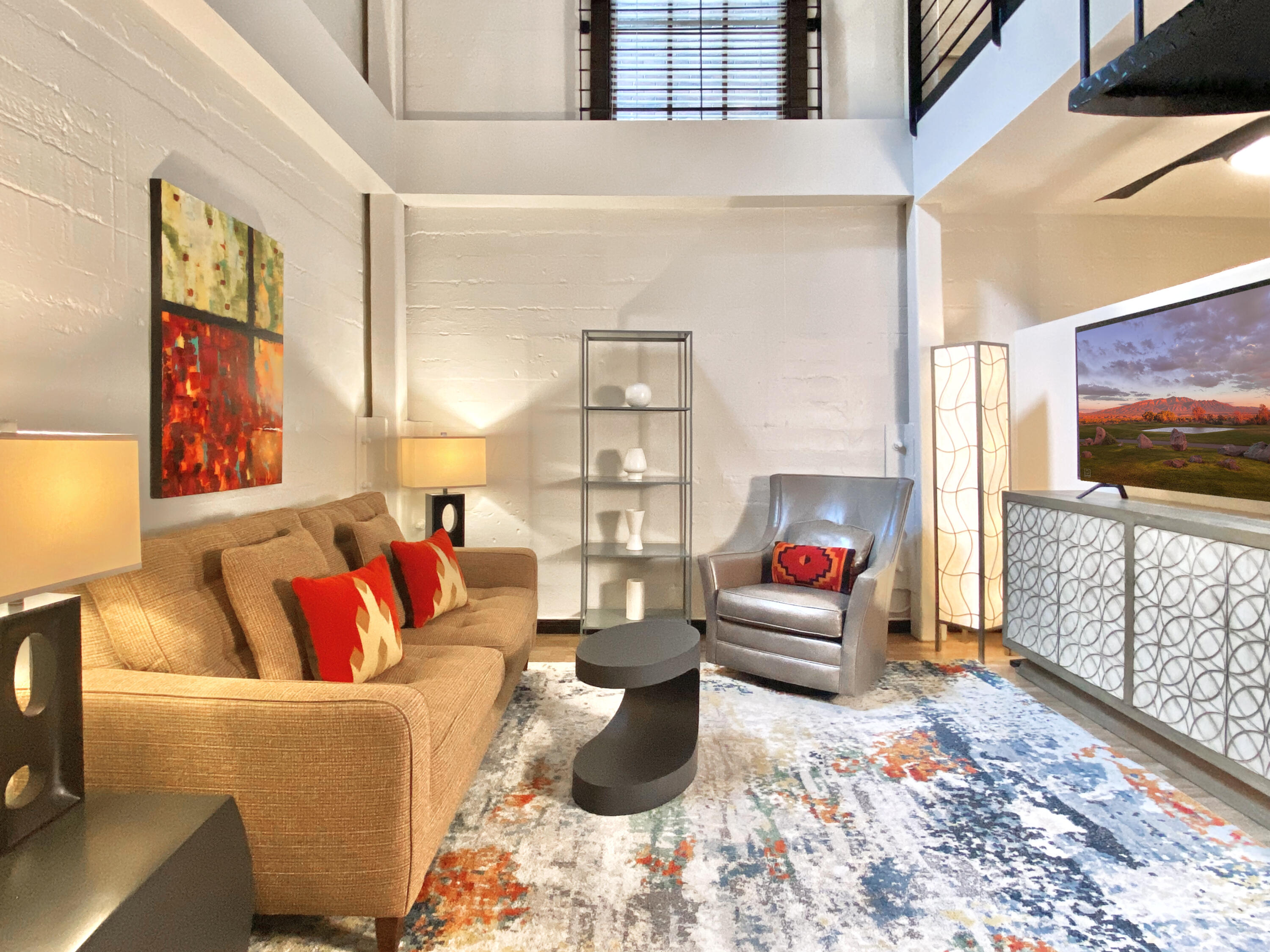 LOFT LIVING at ITS BEST! - One of the best split-level spaces in the landmark Lofts at Albuquerque High residential development. Each level has a separate entrance, one at street level and the other adjacent to the community Laundry and Gym facilities. The quiet 1,230 sq. ft. corner unit, is one of the larger ones in the development. The thoughtful renovation includes a custom kitchen with Fisher & Paykel and Bosch appliances, quartz countertops and an island with a pull out table top. The secure campus, is centrally located and surrounded by outdoor green spaces and fountains in all directions. Seller will consider selling the unique furnishings which are the perfect scale for the space. A vibrant and diverse community awaits you. Make yourself at home right in the heart of the city!