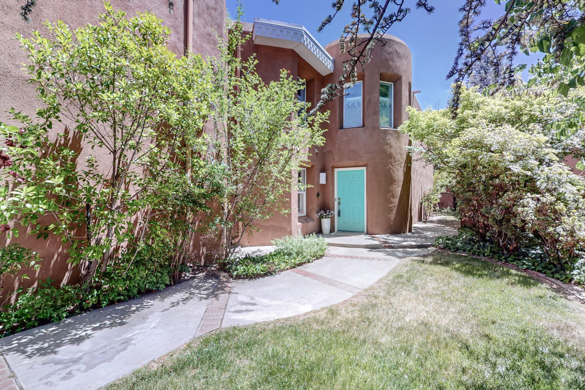 Quiet, private, community just a stone's throw from the Bosque. Neighborhood is filled with SW architecture and loaded with CHARM. Enter thegated courtyard, and be greeted with lush trees, shrubs, and flowers. Once inside - circular foyer with soaring ceilings and hand carve beams that extend into the living room will WOW you! Window wall and french doors to the patio allow lots of natural light and looks out into a  backyard oasis. Formal dining off the living leads to a stunning kitchen remodel and breakfast nook - also looking out back. Downstairs bedroom/office includes french doors and easy bathroom access.  Circular staircase leads upstairs to a huge primary bedroom and an additional ensuite bedroom including an office.  Don't miss this great opportunity for Valley Living!