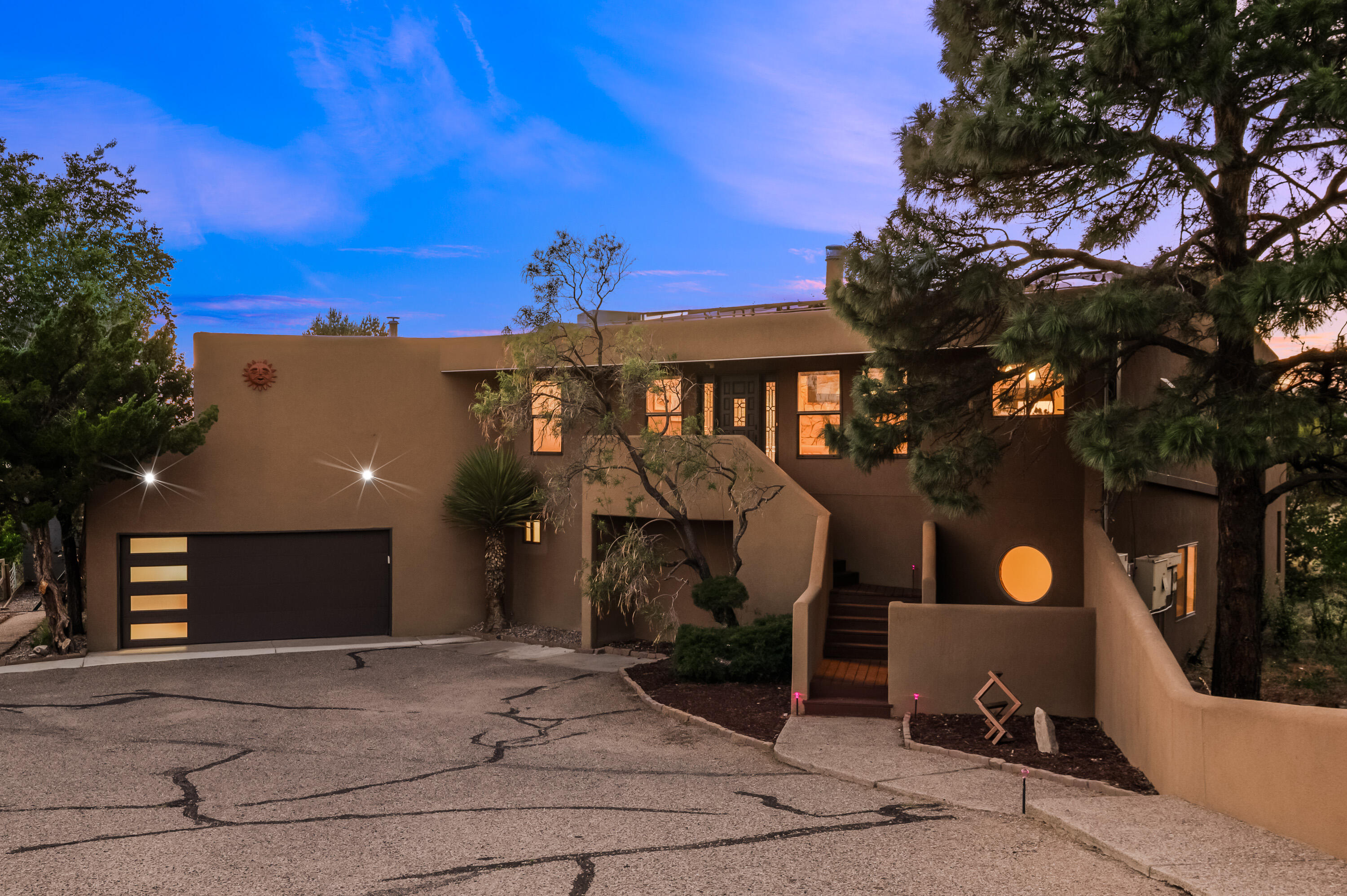 Architectural sophistication and thoughtful upgrades define this striking Sandia Heights retreat. Designed to harmonize with its natural surroundings, this solar-powered home features 3 spacious bedrooms, and an optional 4th, 3 baths, flex spaces and two levels of inspired living. Expansive windows and an open, light-filled floor plan showcase sweeping views of the Sandia Mountains and city lights. Enjoy the private hot tub, generous deck, and direct access to foothill trails. With curated enhancements and timeless design, this home is a rare blend of form, function, and elevated Southwest living.